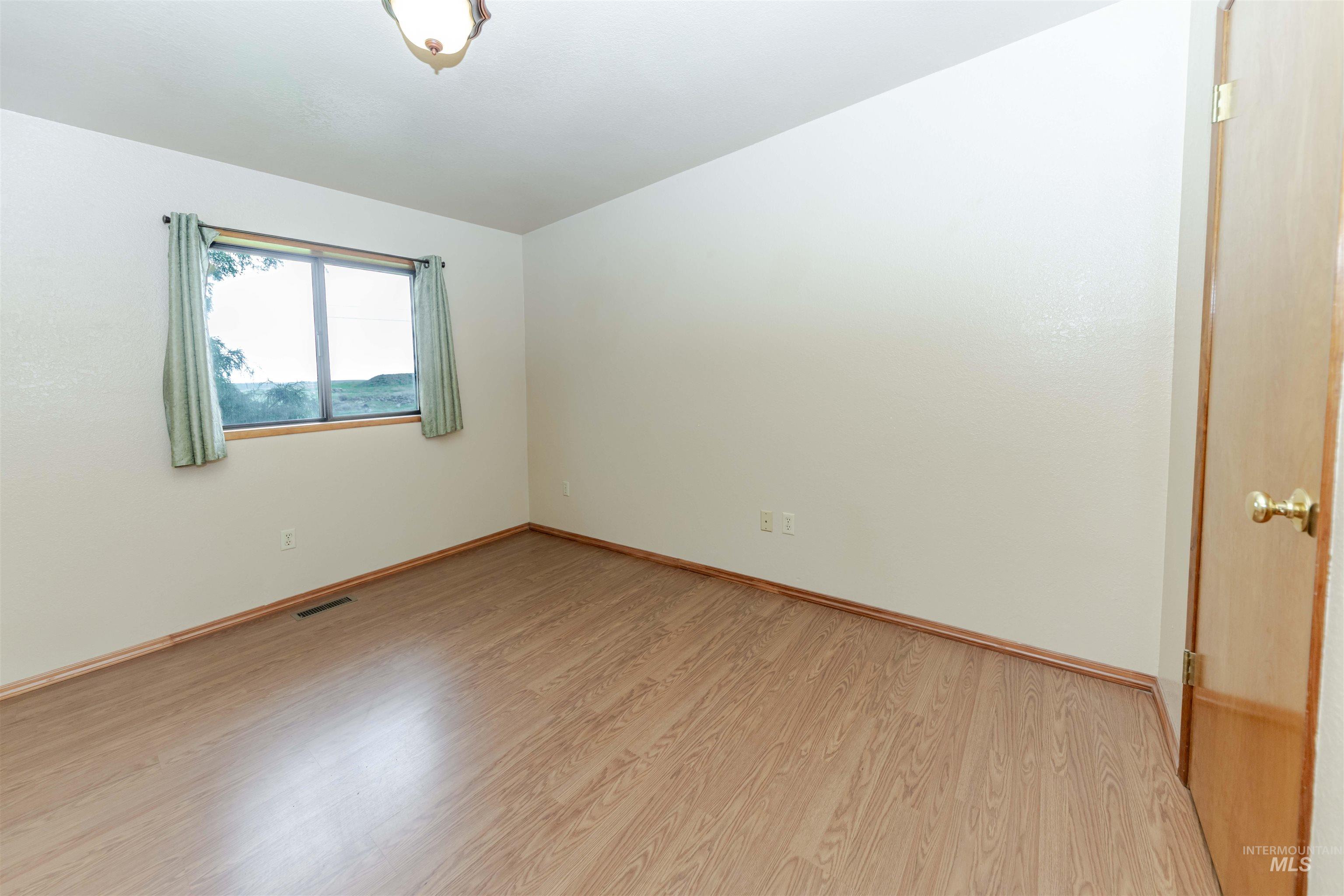 Bedroom with light wood finished floors and baseboards