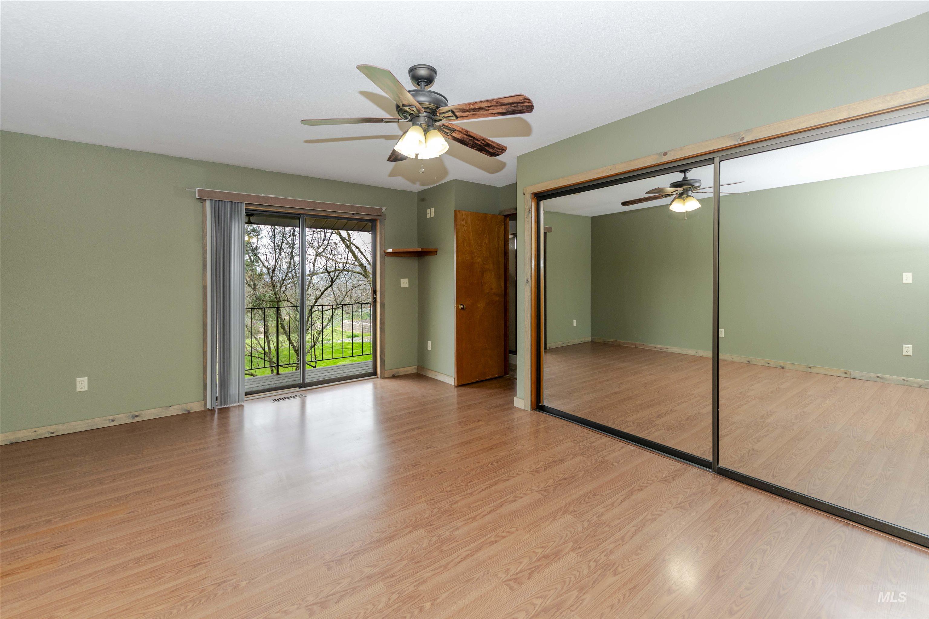 Primary bedroom featuring access to outside, light wood finished floors, a closet, and ceiling fan