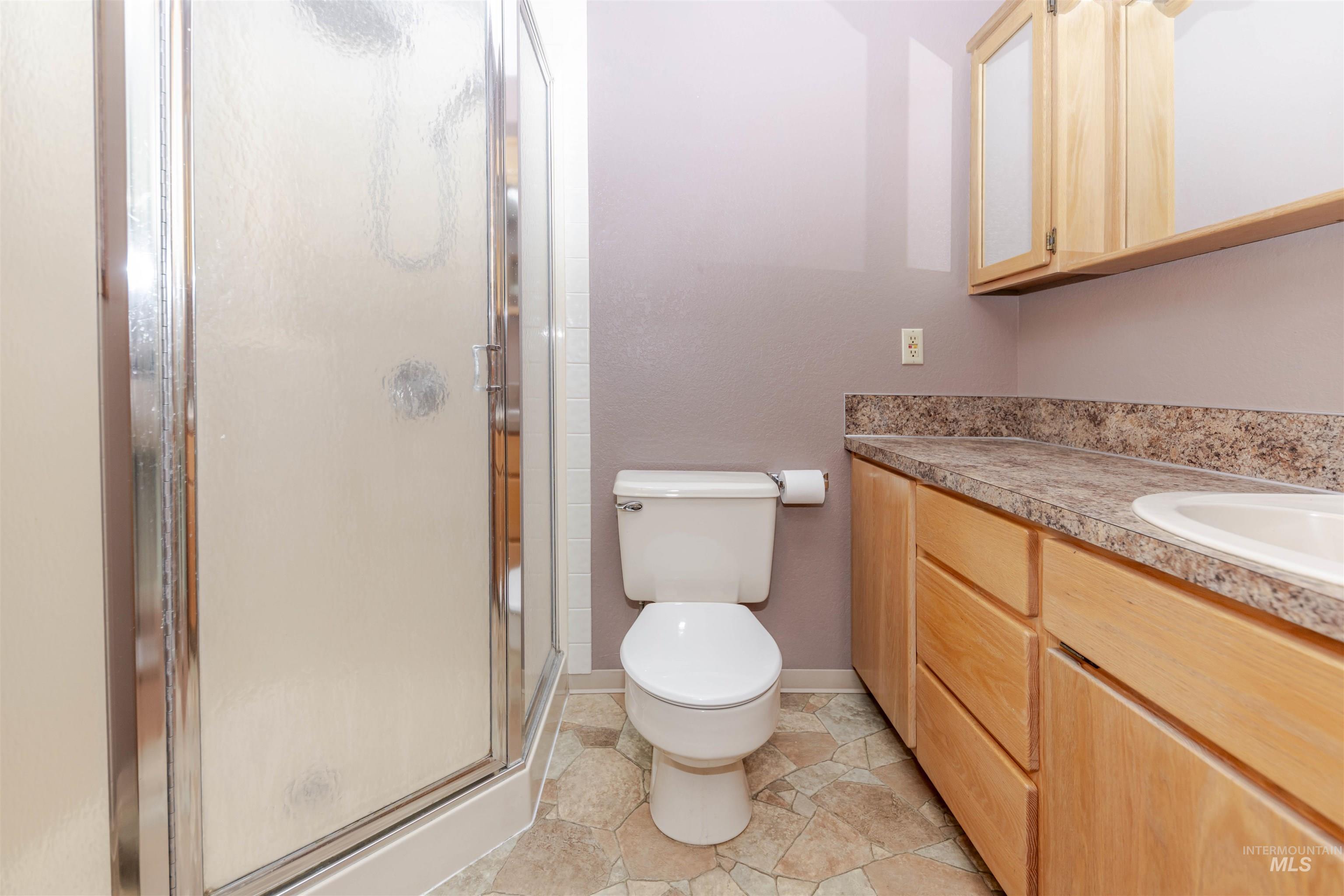 Primary bathroom featuring a shower stall and vanity