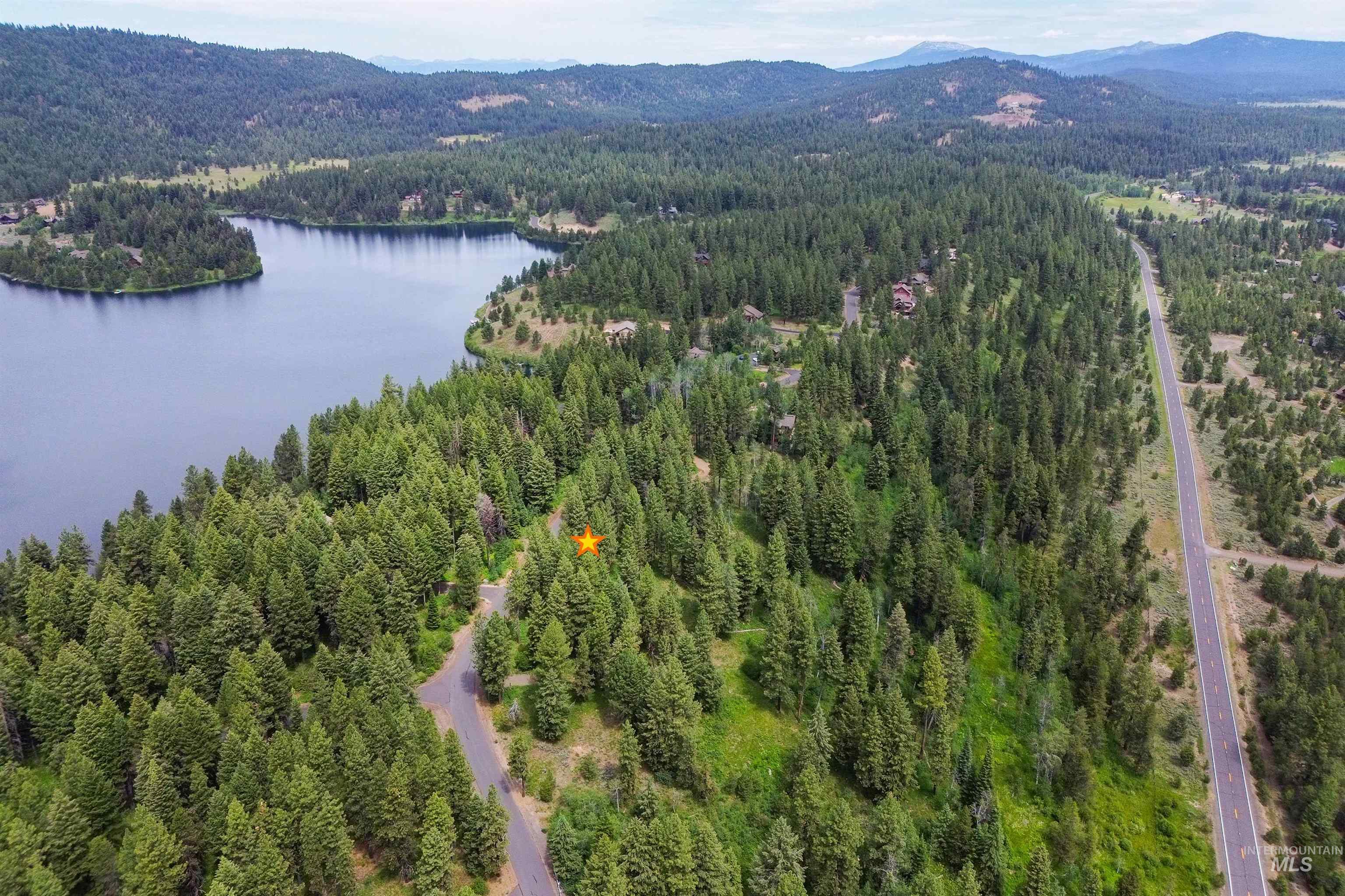 Aerial view of a heavily wooded area and a water and mountain view