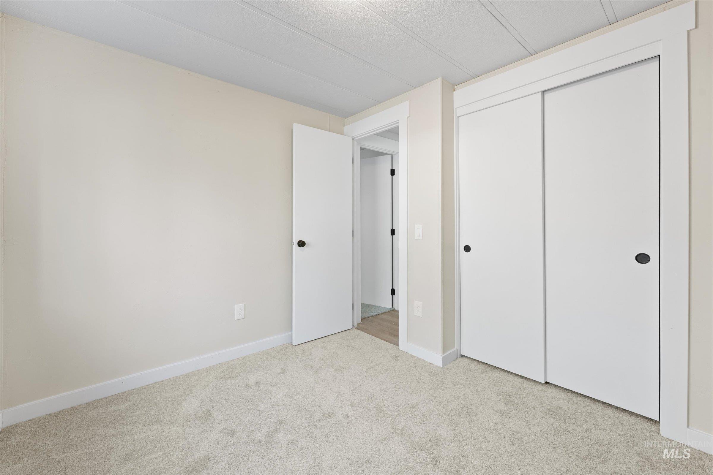 Unfurnished bedroom featuring light colored carpet and a closet