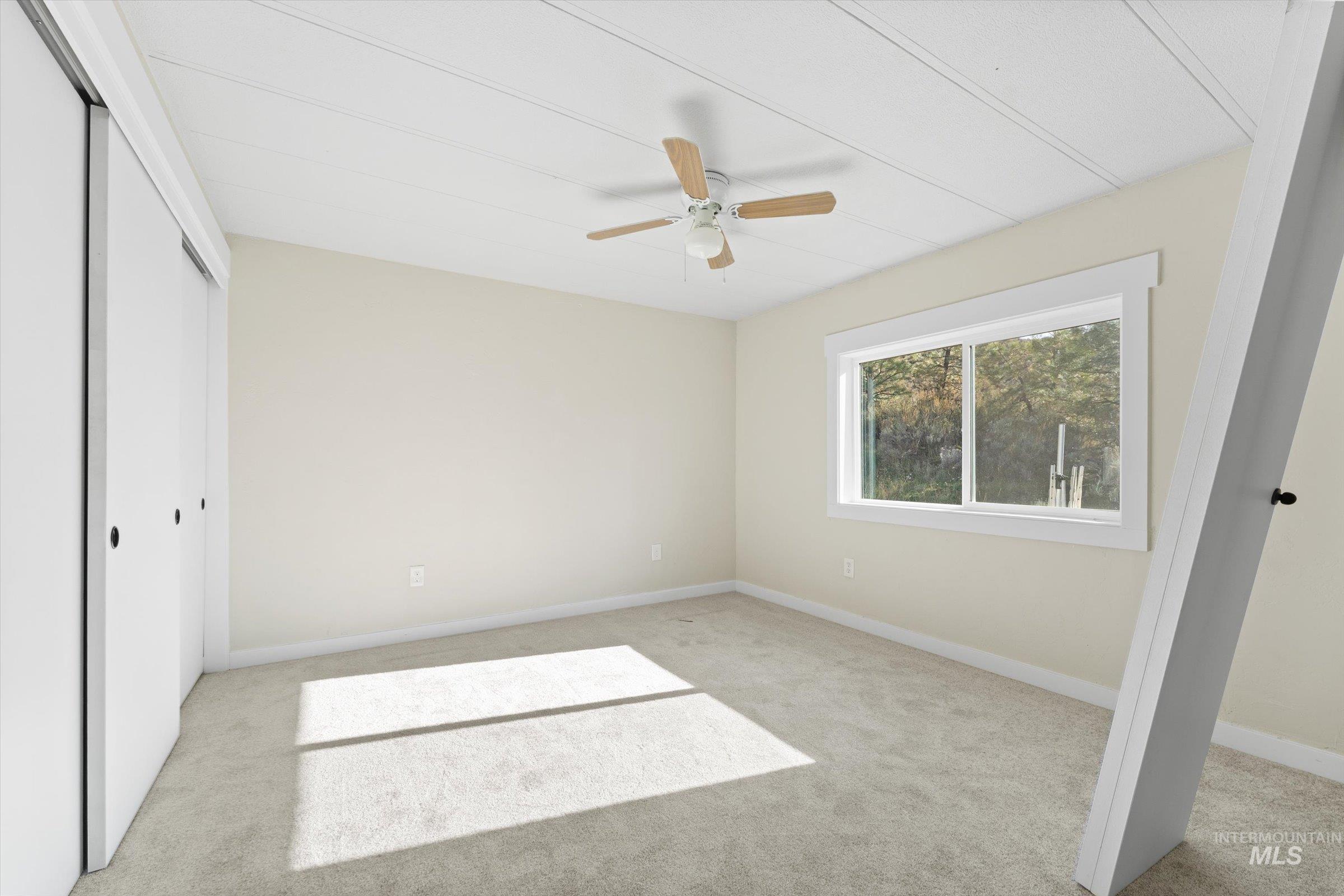Unfurnished bedroom featuring a closet, ceiling fan, and light colored carpet