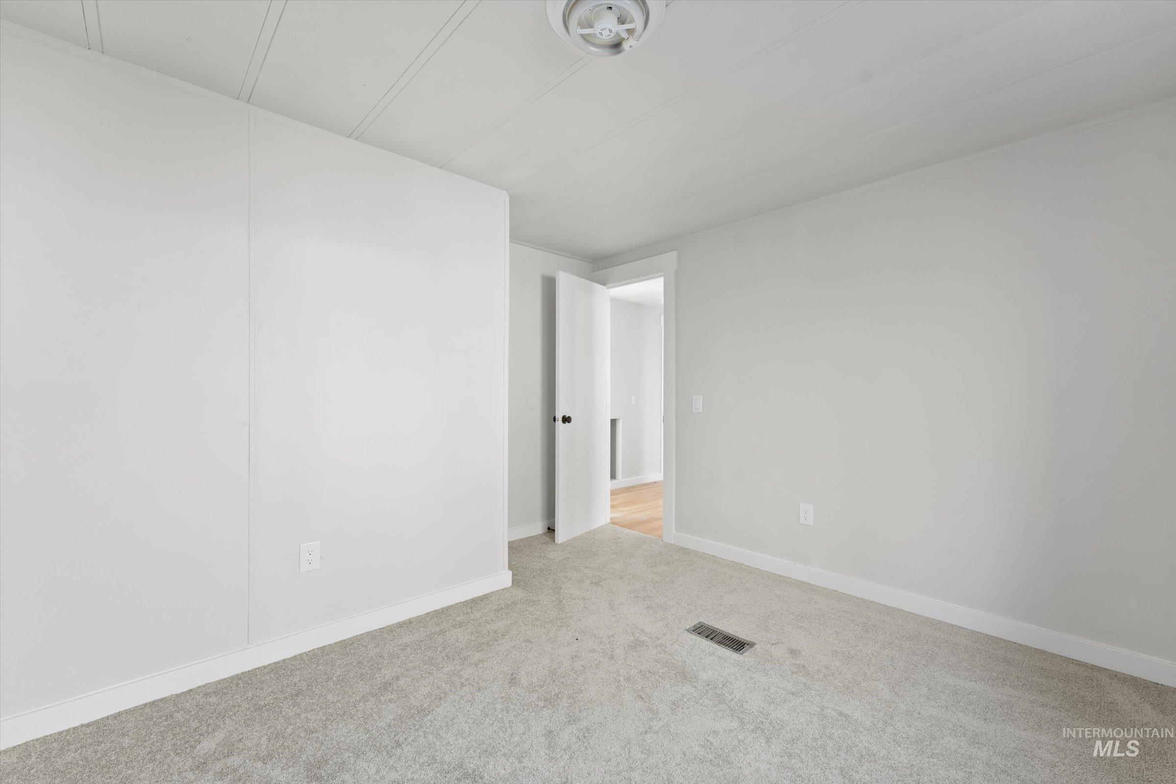Carpeted empty room with baseboards