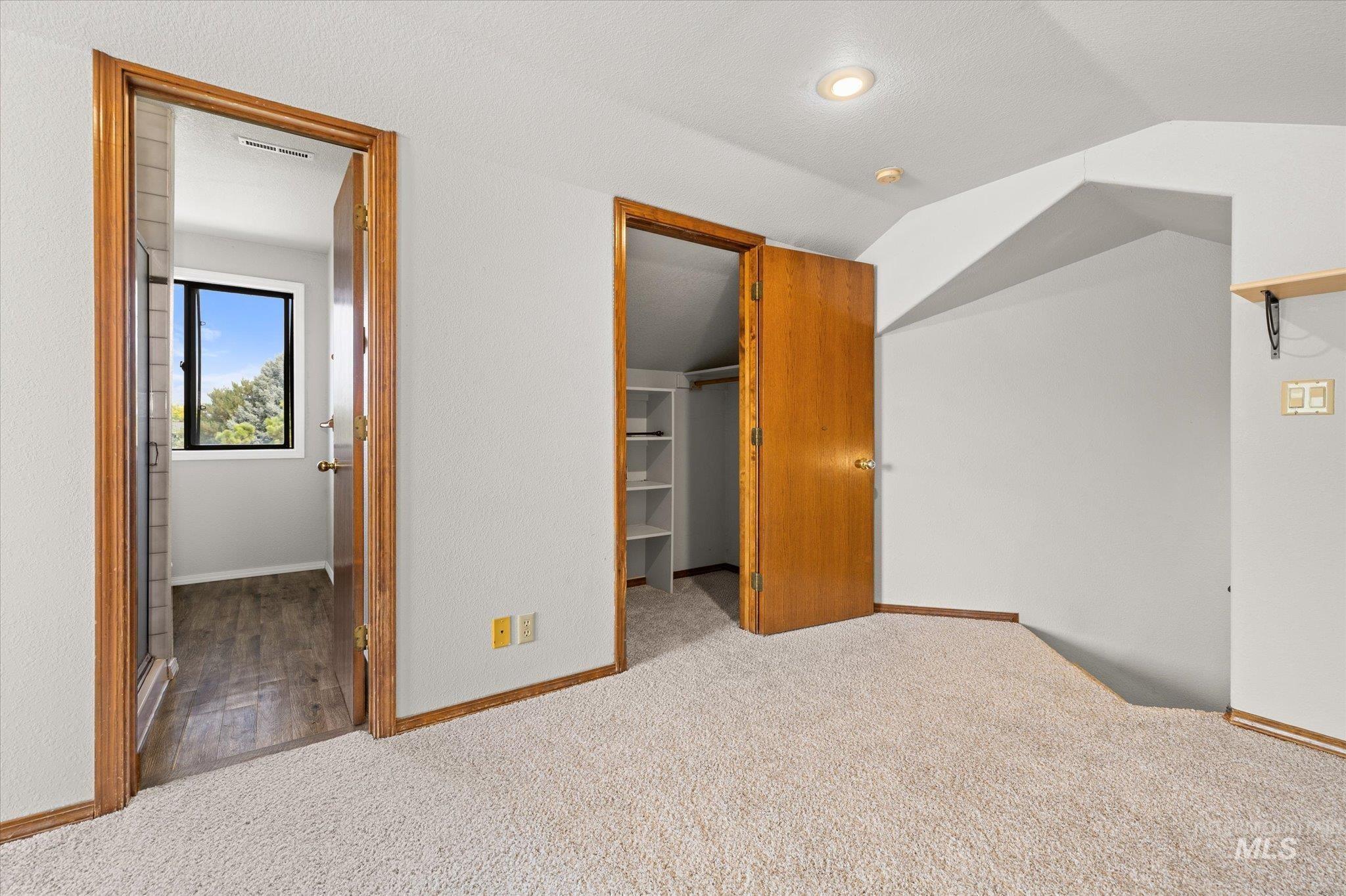 Additional living space with carpet flooring and vaulted ceiling