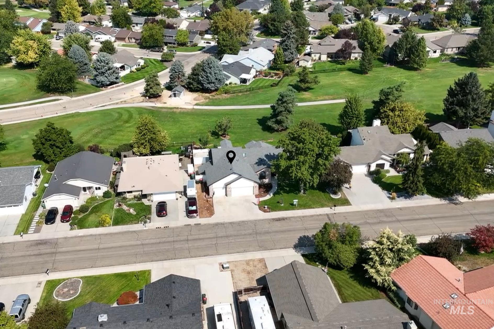 Aerial view of property and surrounding area featuring nearby suburban area