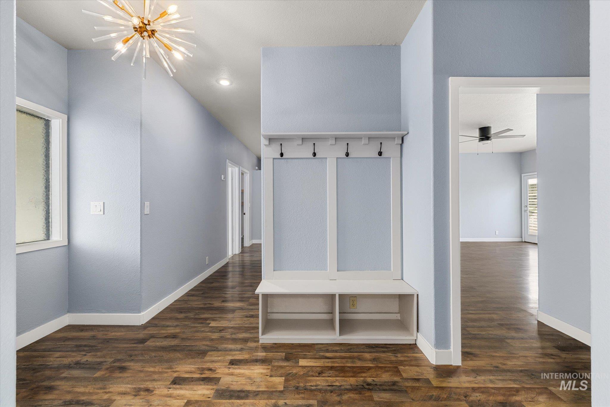 Mudroom featuring a chandelier and dark wood-type flooring