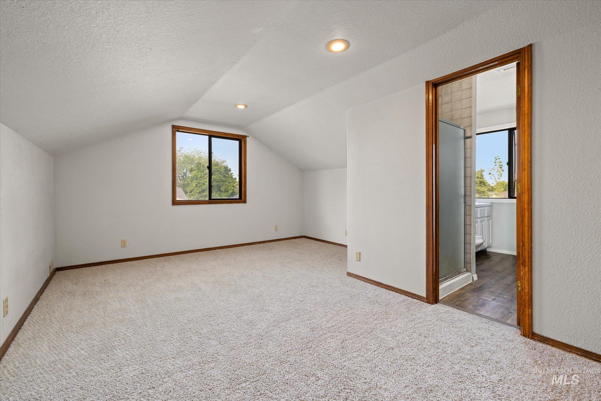 Bonus room featuring a textured ceiling, light colored carpet, lofted ceiling, and recessed lighting