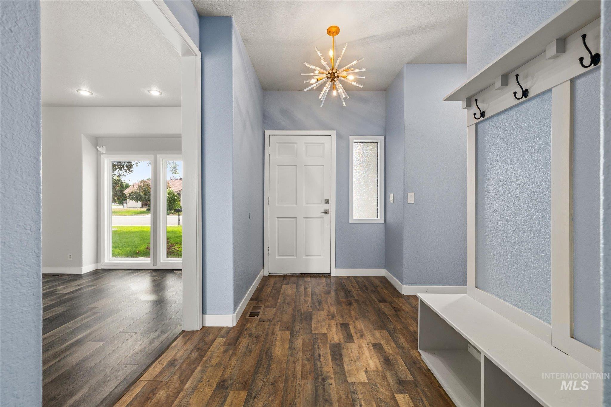 Mudroom featuring a chandelier, dark wood-type flooring, and recessed lighting