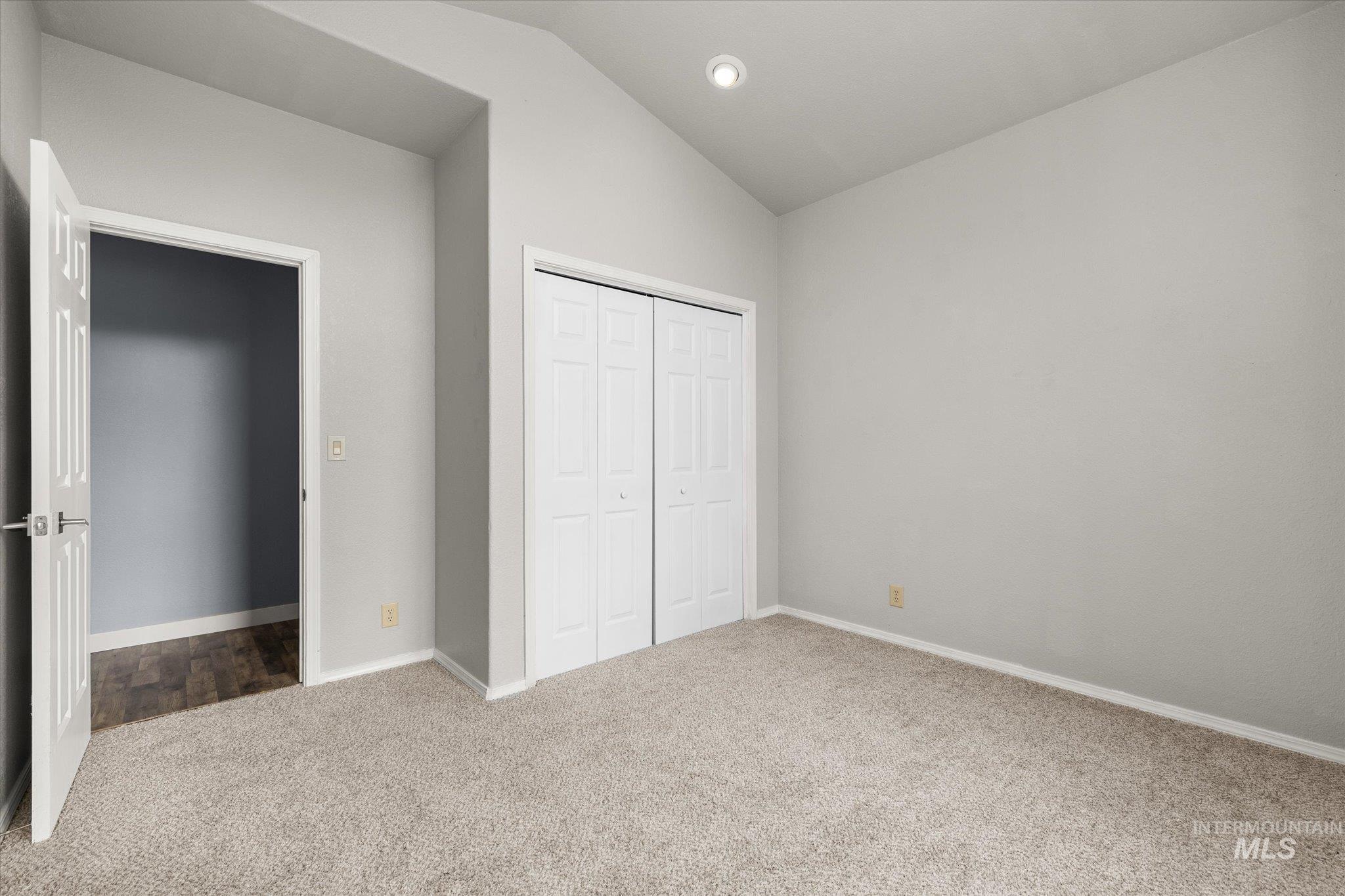 Unfurnished bedroom featuring lofted ceiling, carpet floors, a closet, and recessed lighting
