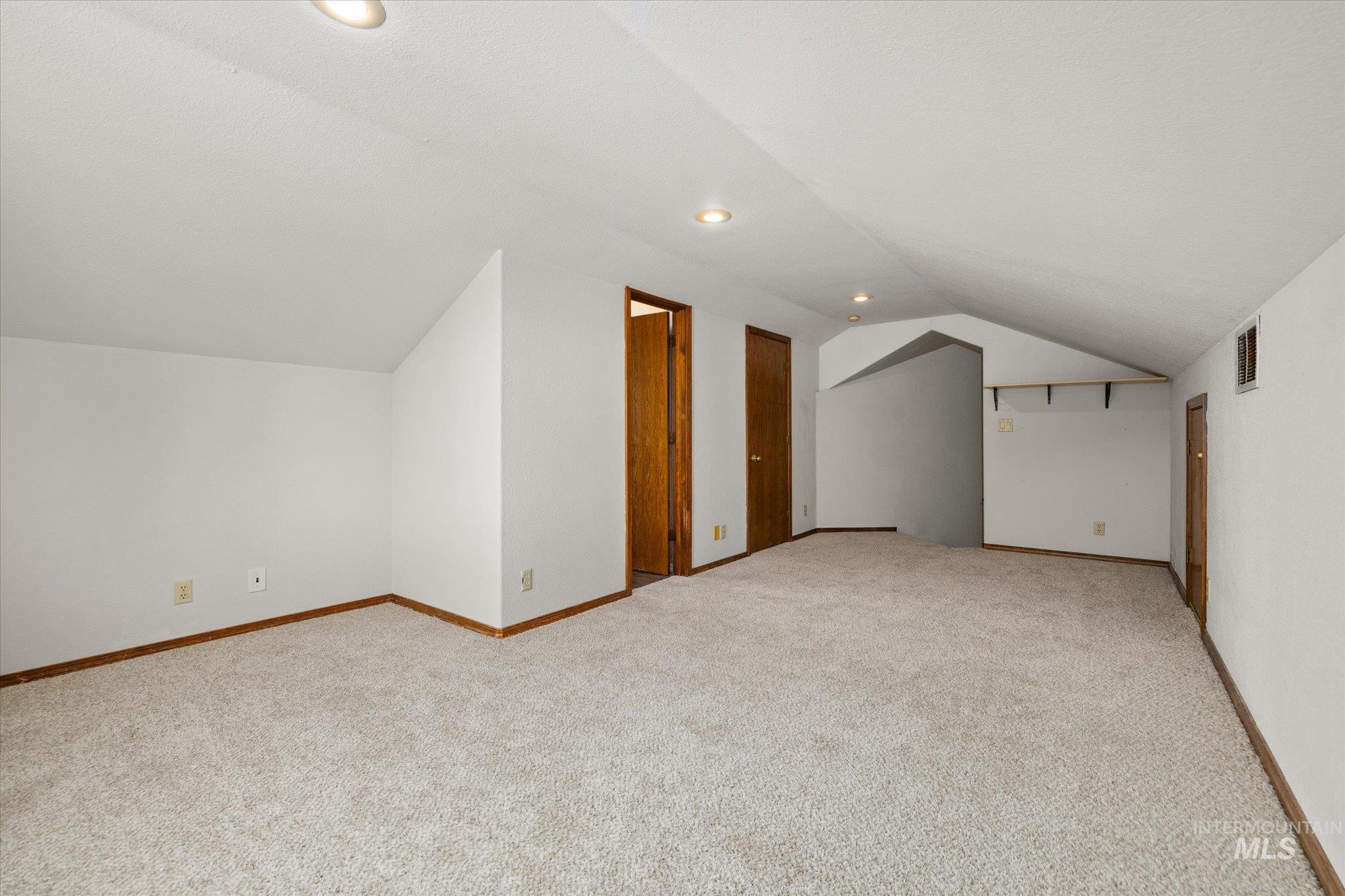 Bonus room featuring lofted ceiling, light carpet, and recessed lighting