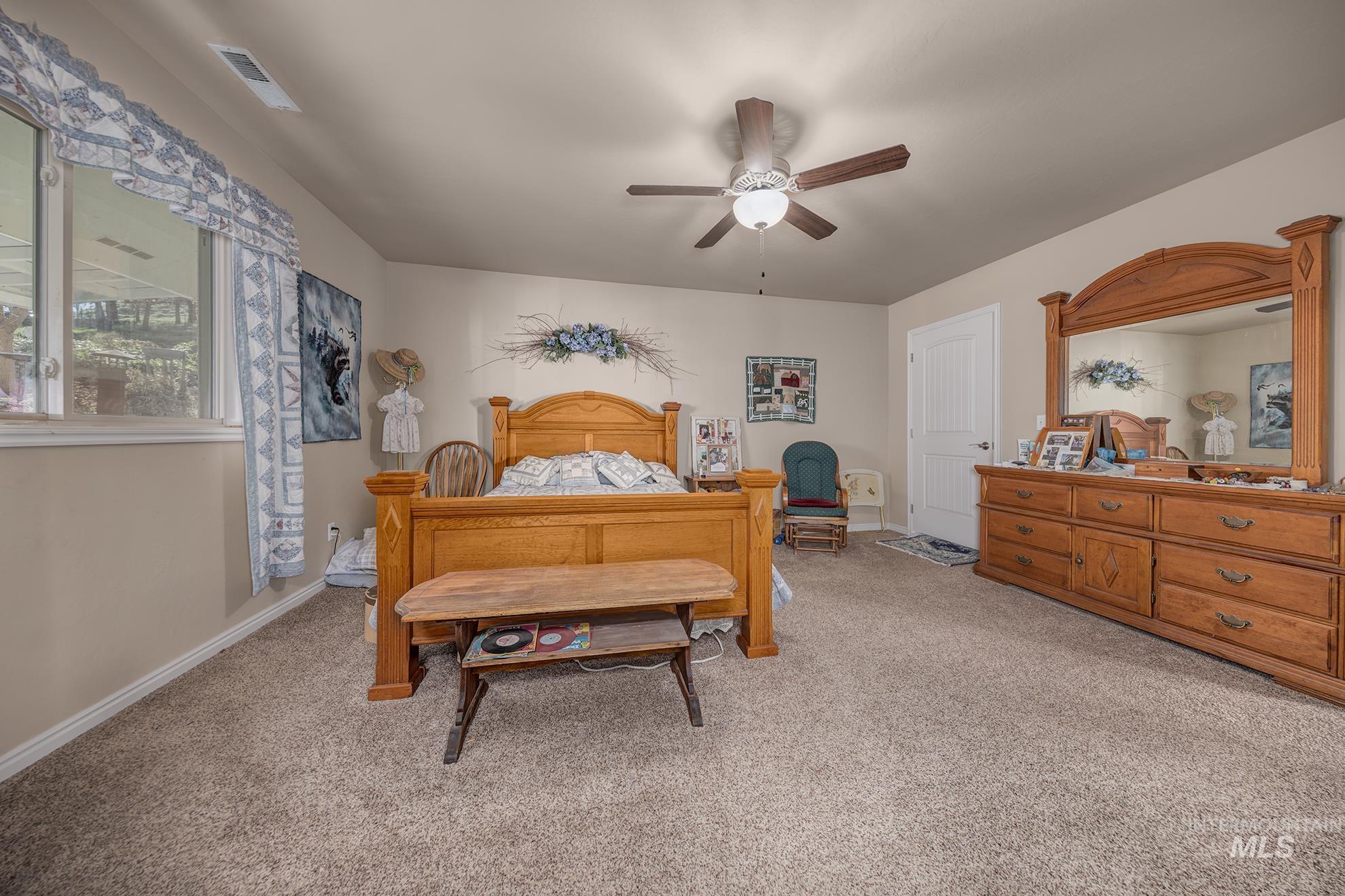 Bedroom featuring light colored carpet and ceiling fan
