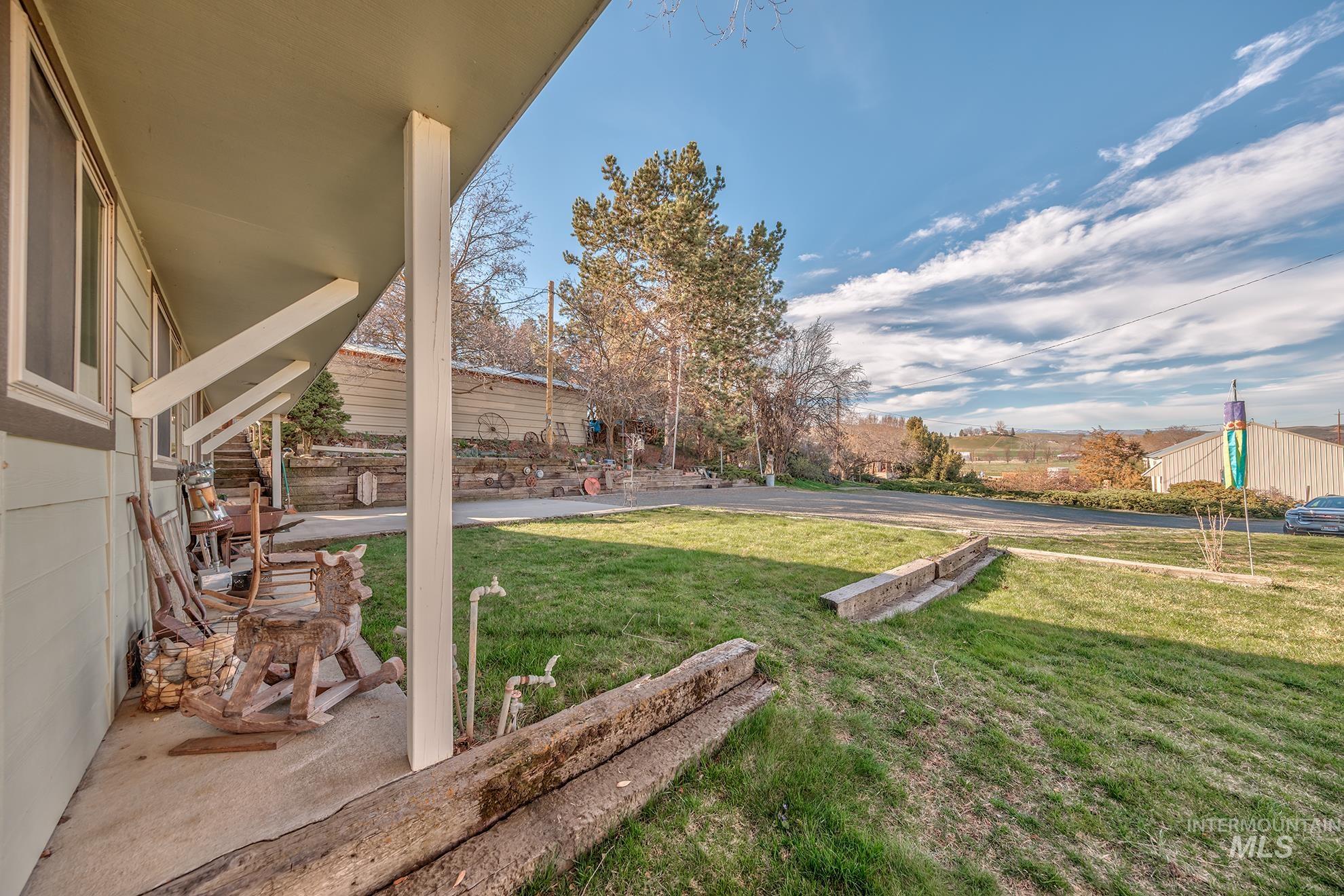 View of grassy yard featuring covered porch