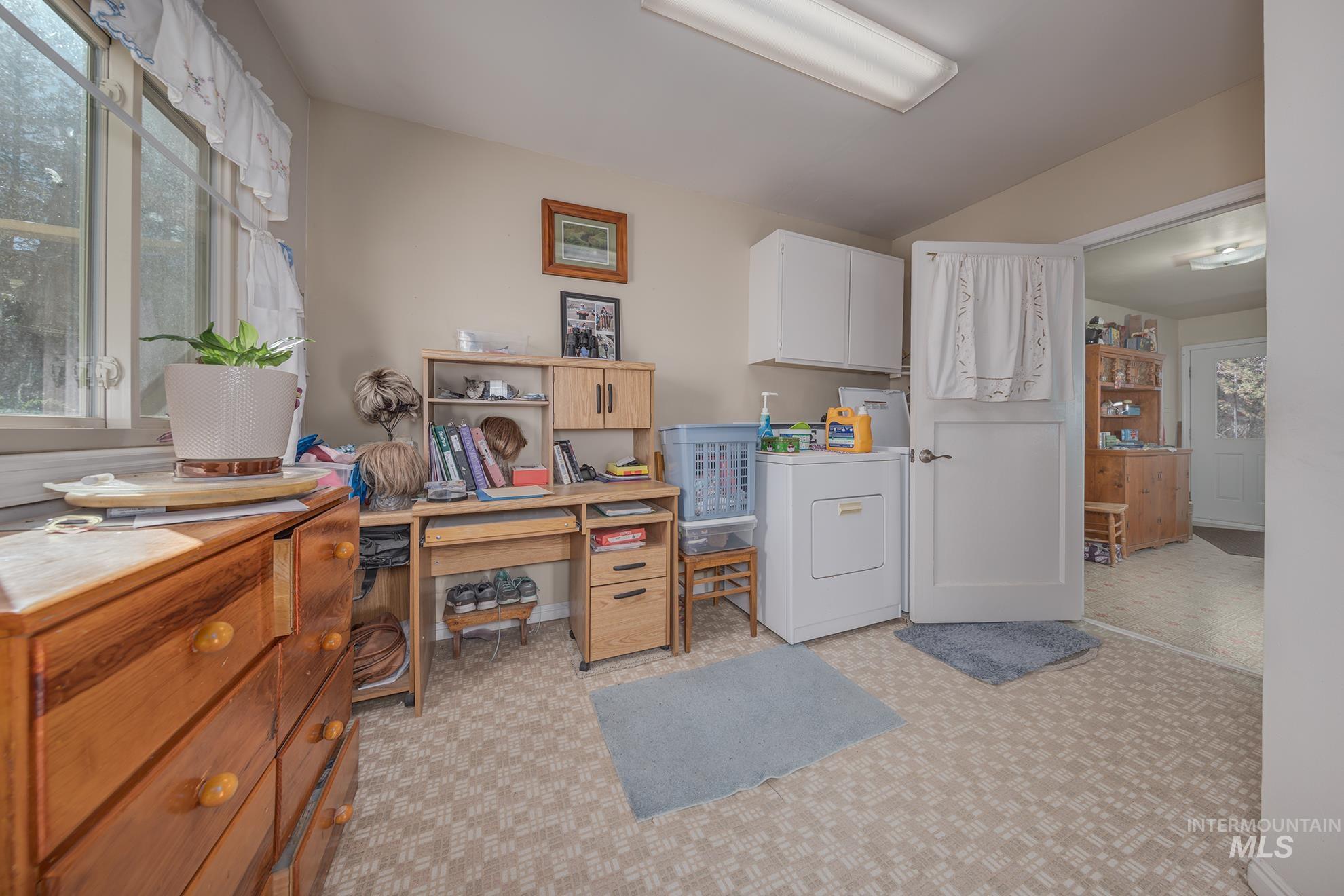 Laundry room featuring plenty of natural light, an office area, cabinet space, and washer / dryer