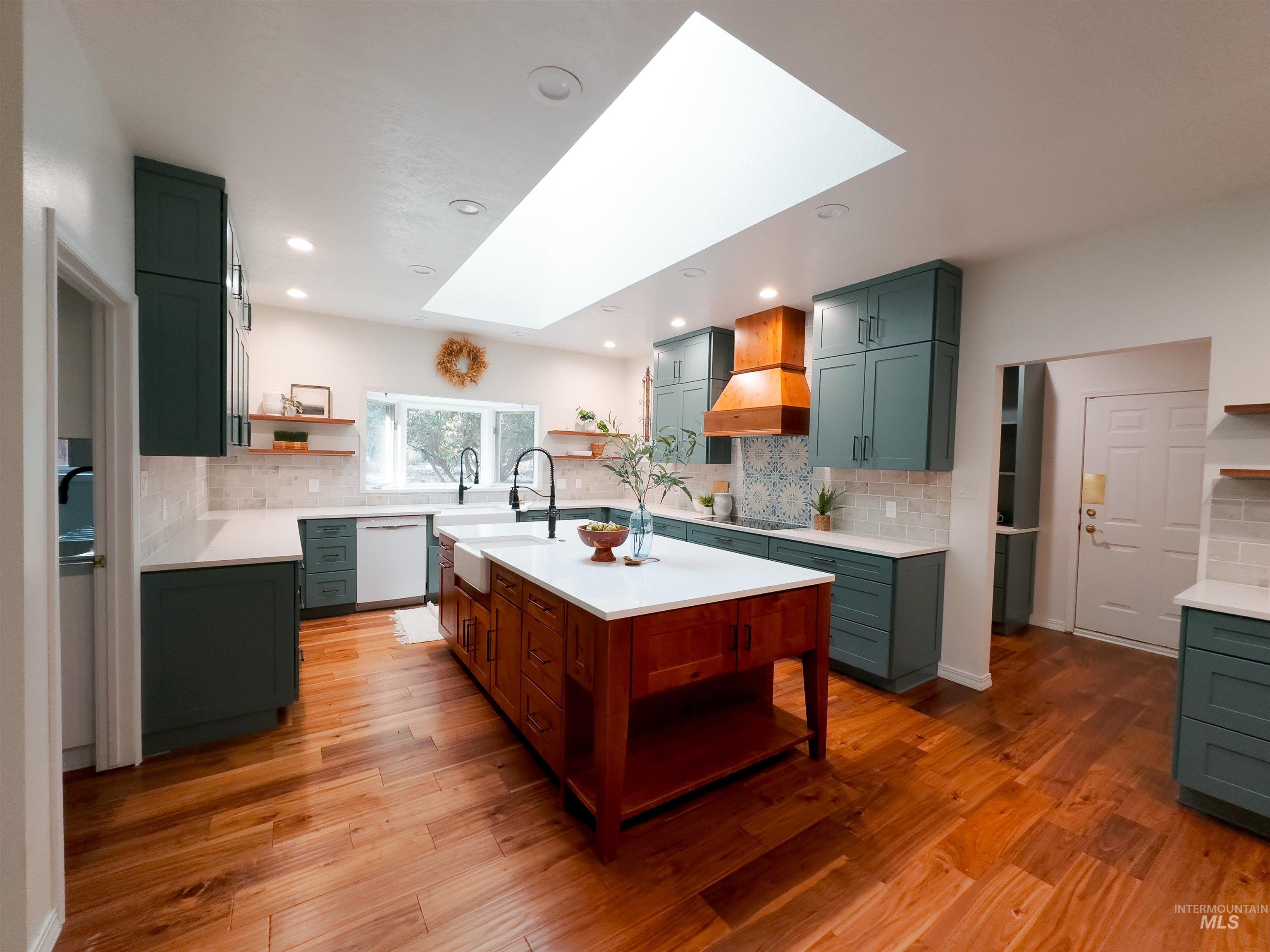 Kitchen featuring open shelves, green cabinets, a skylight, backsplash, and recessed lighting