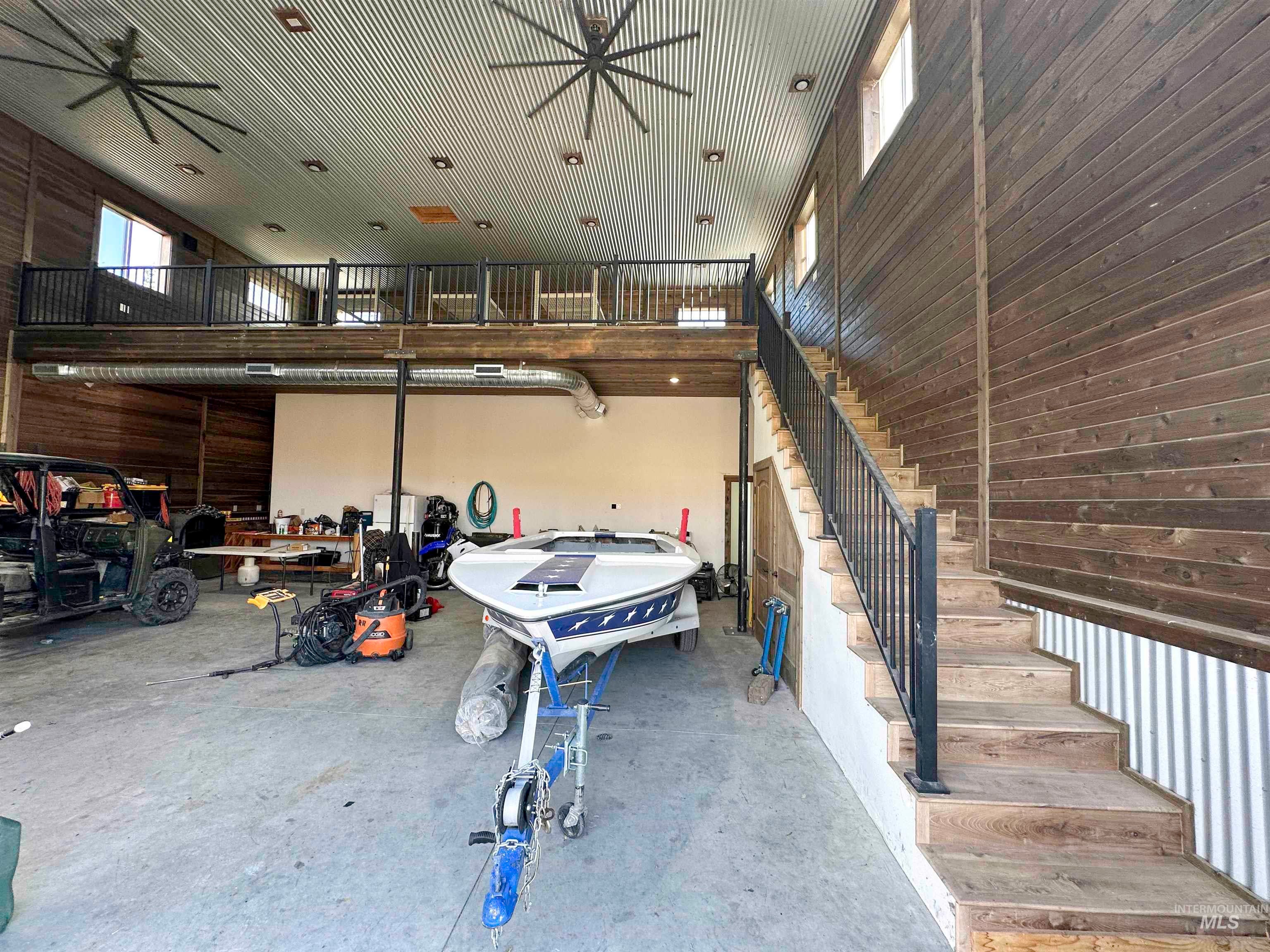Garage featuring wooden walls and ceiling fan