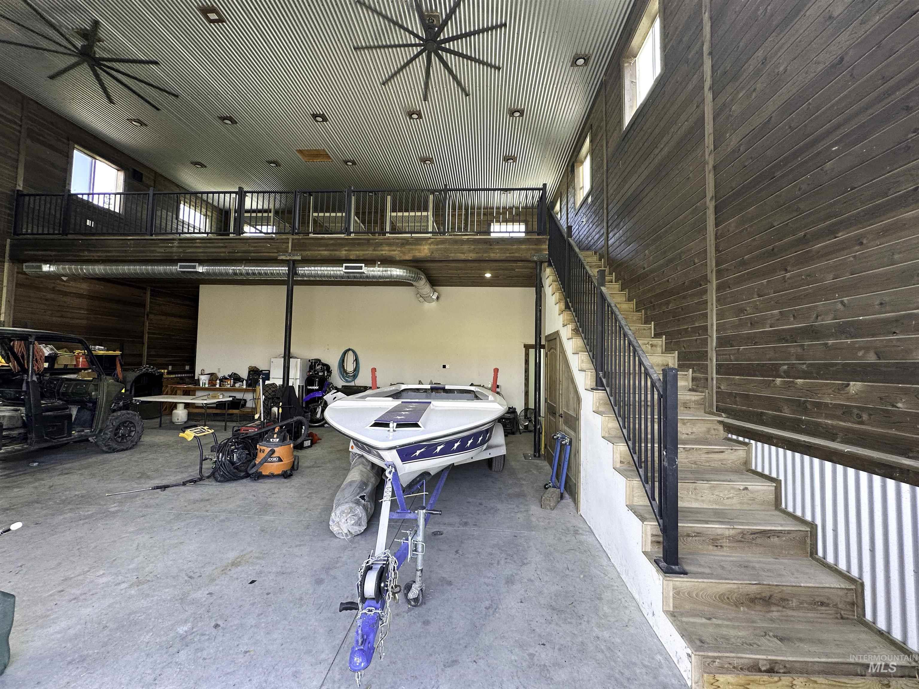 Garage featuring wooden walls and ceiling fan