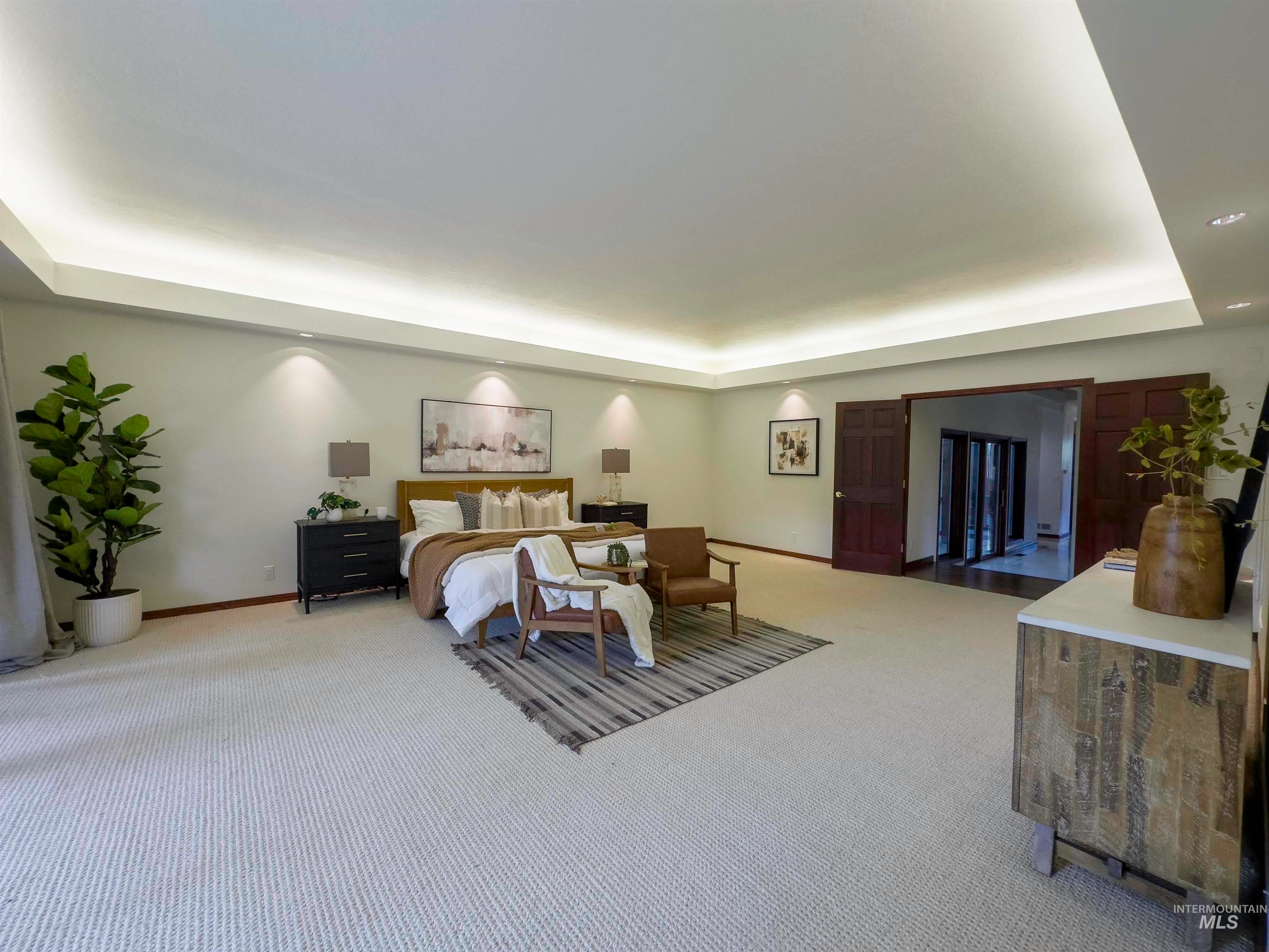 Bedroom with a tray ceiling and carpet
