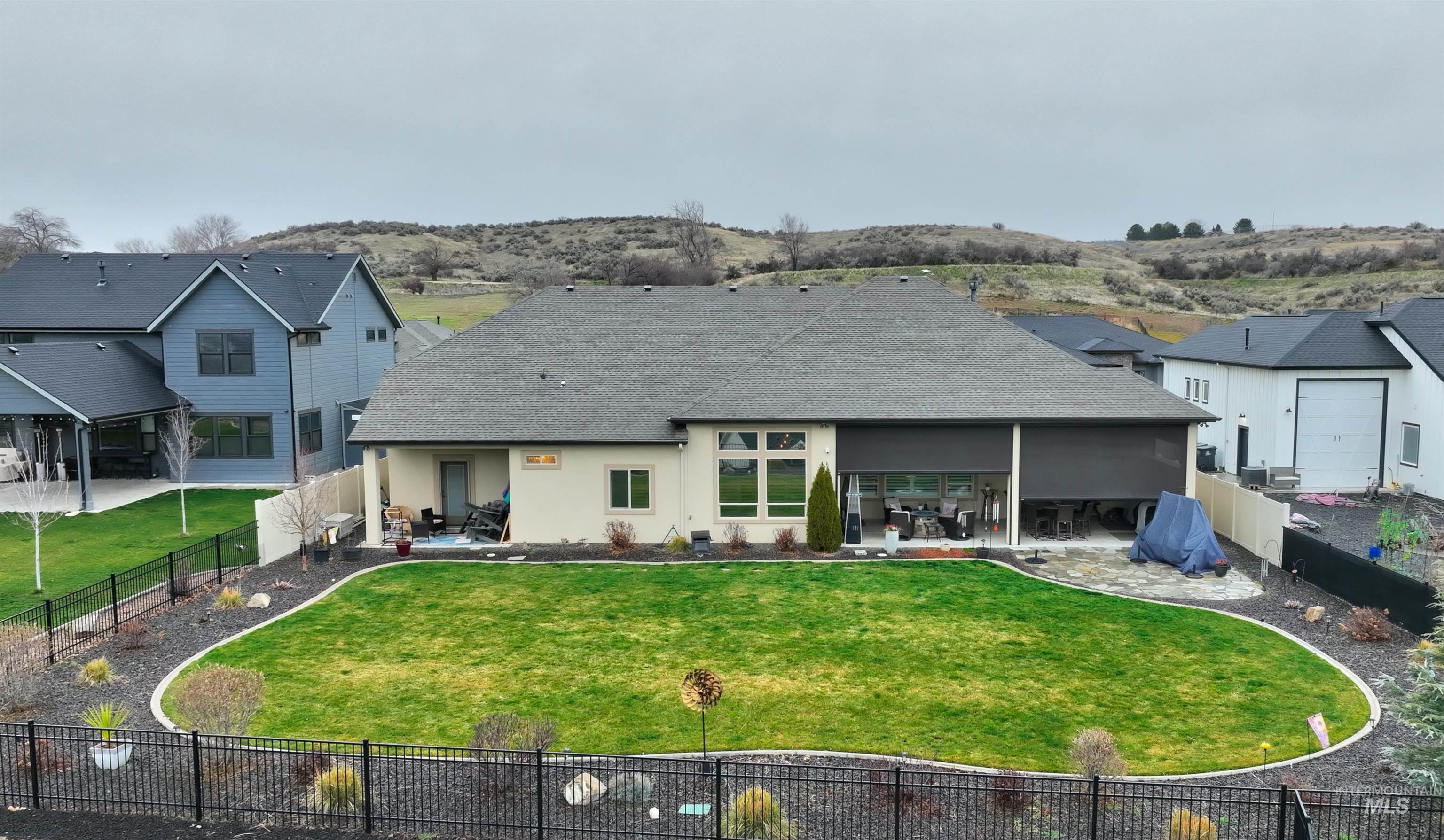 Back of property with a patio, a fenced backyard, a shingled roof, and stucco siding