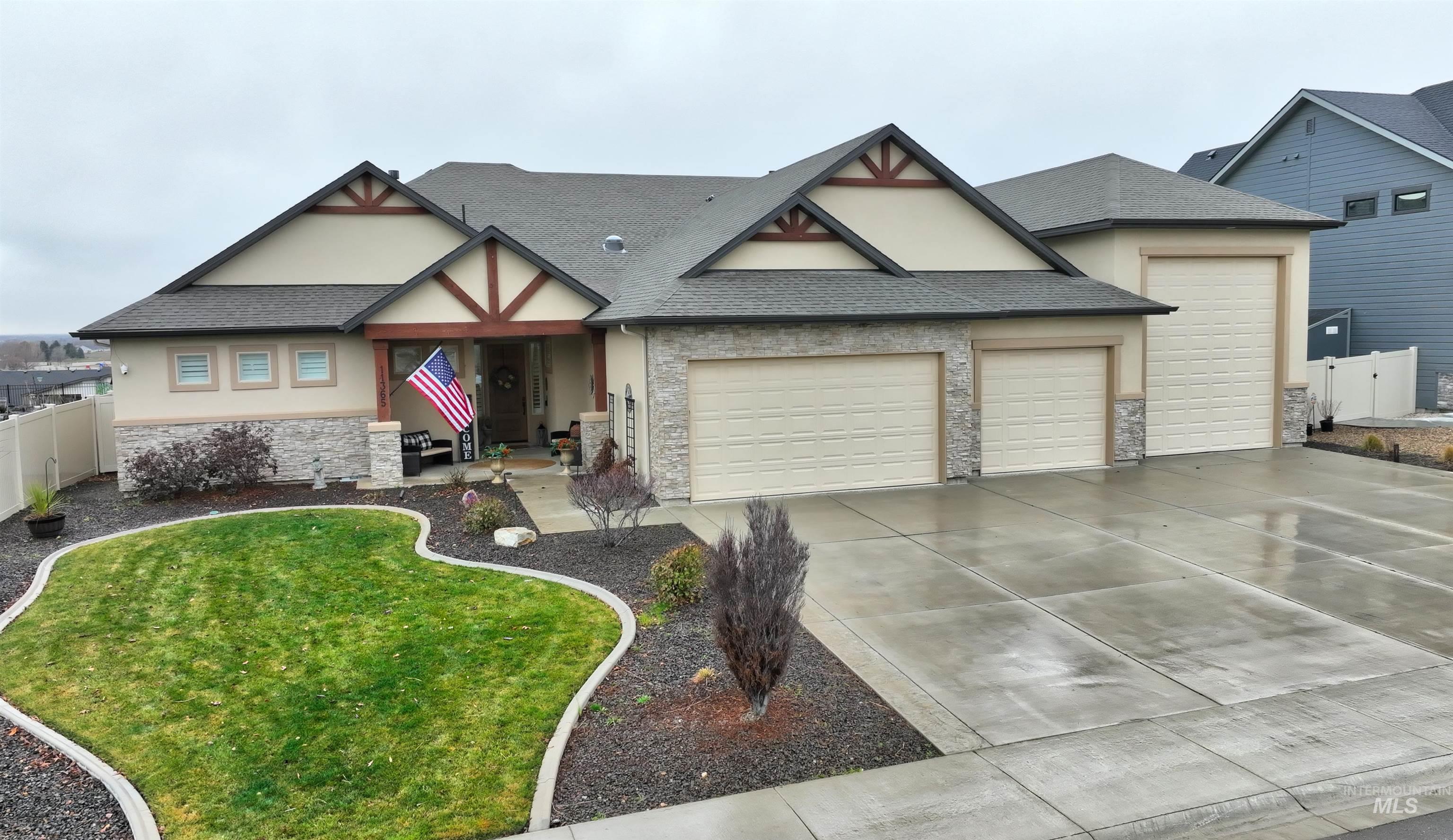 Tudor-style house with stone siding, covered porch, an attached garage, stucco siding, and driveway