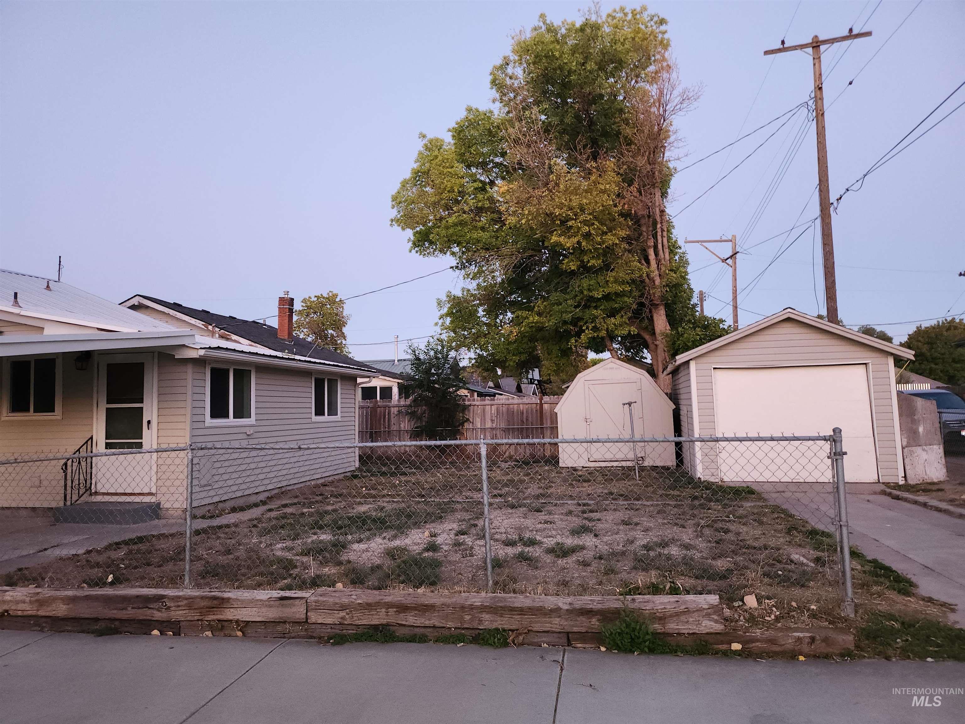 Fenced yard with a garage and a storage shed