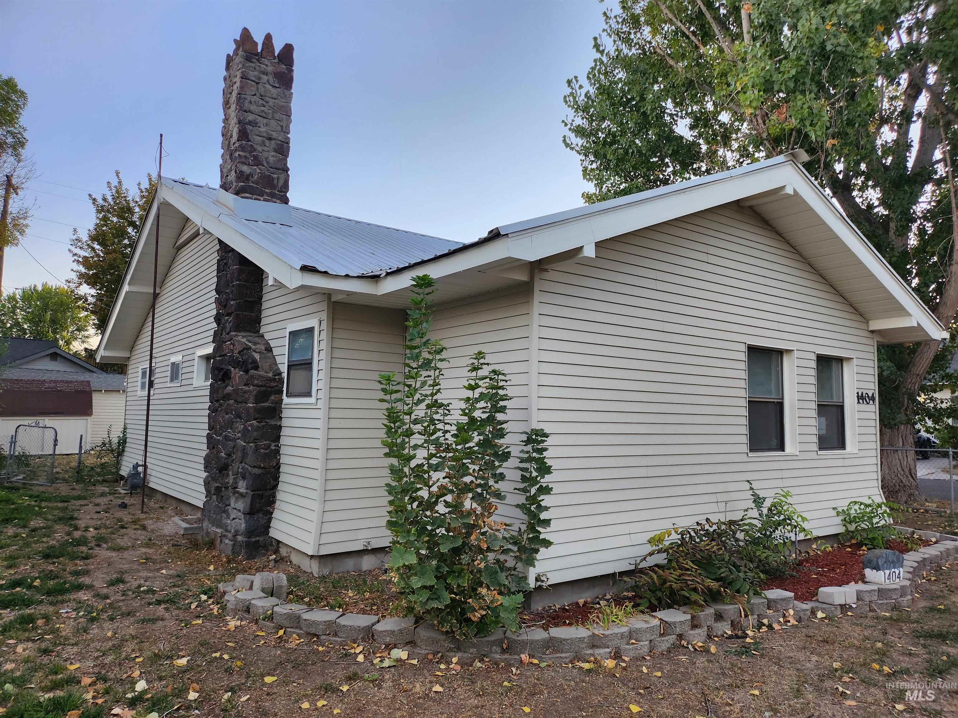 View of side of home with a metal roof and a chimney