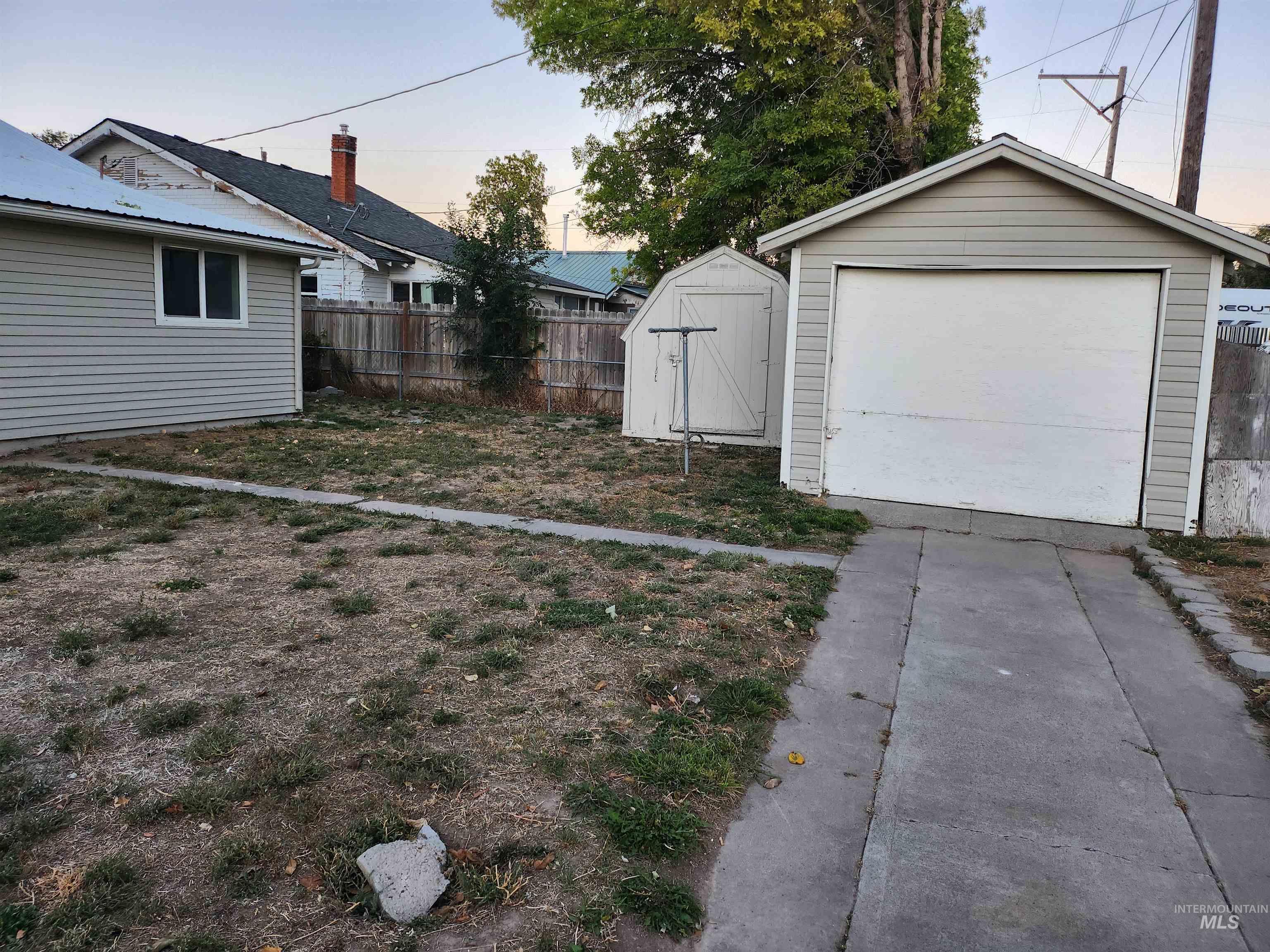 View of yard featuring a storage unit, a detached garage, and driveway