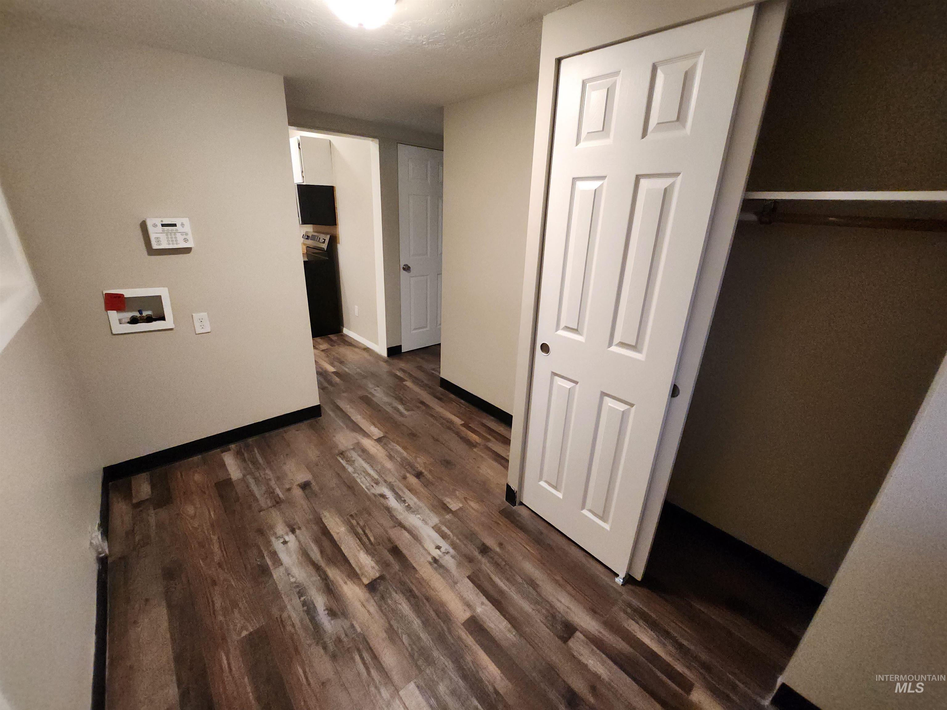 Washroom featuring dark wood-style flooring and hookup for a washing machine