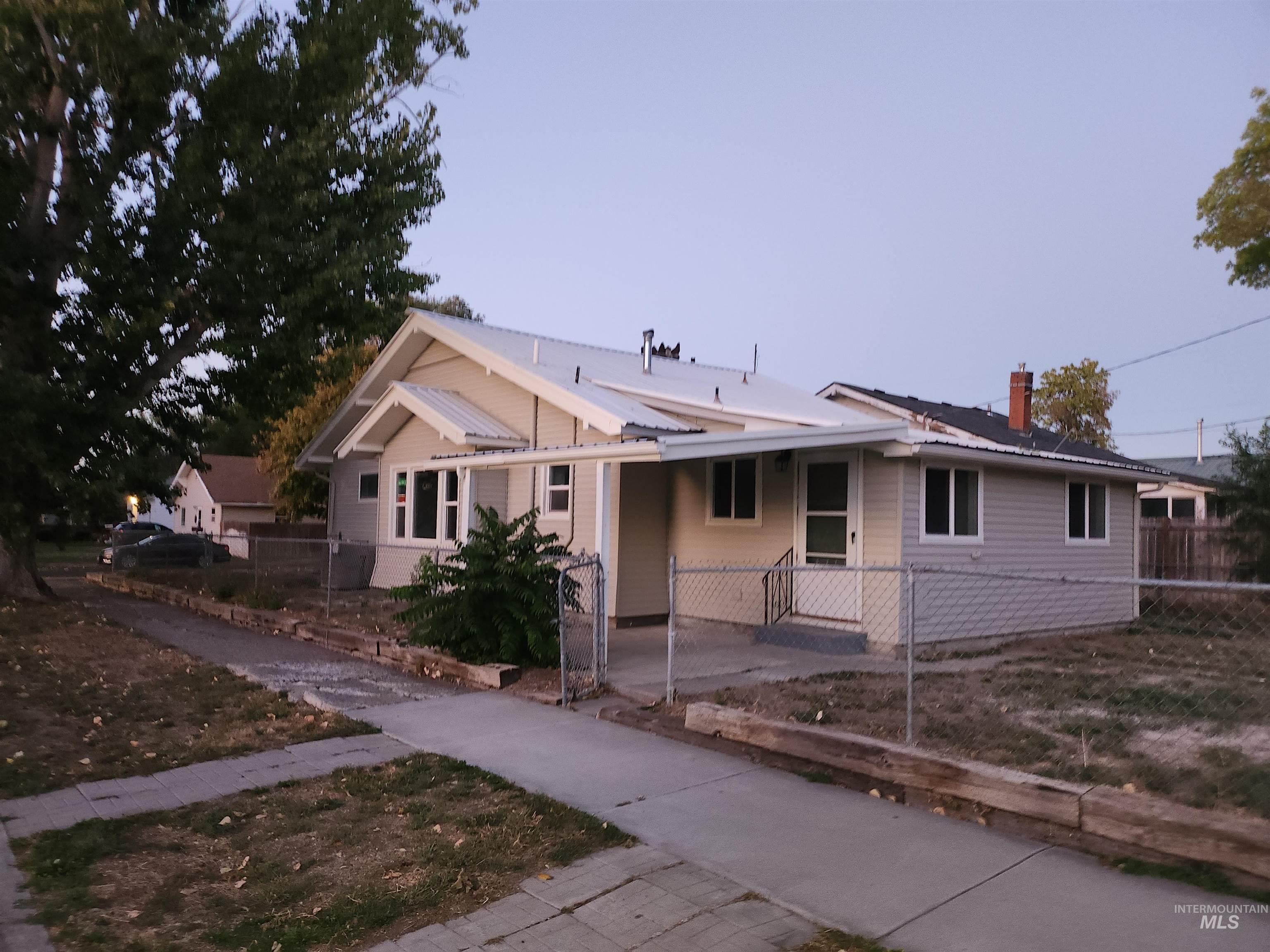 View of front of house with a fenced front yard, a chimney, an attached carport, and driveway
