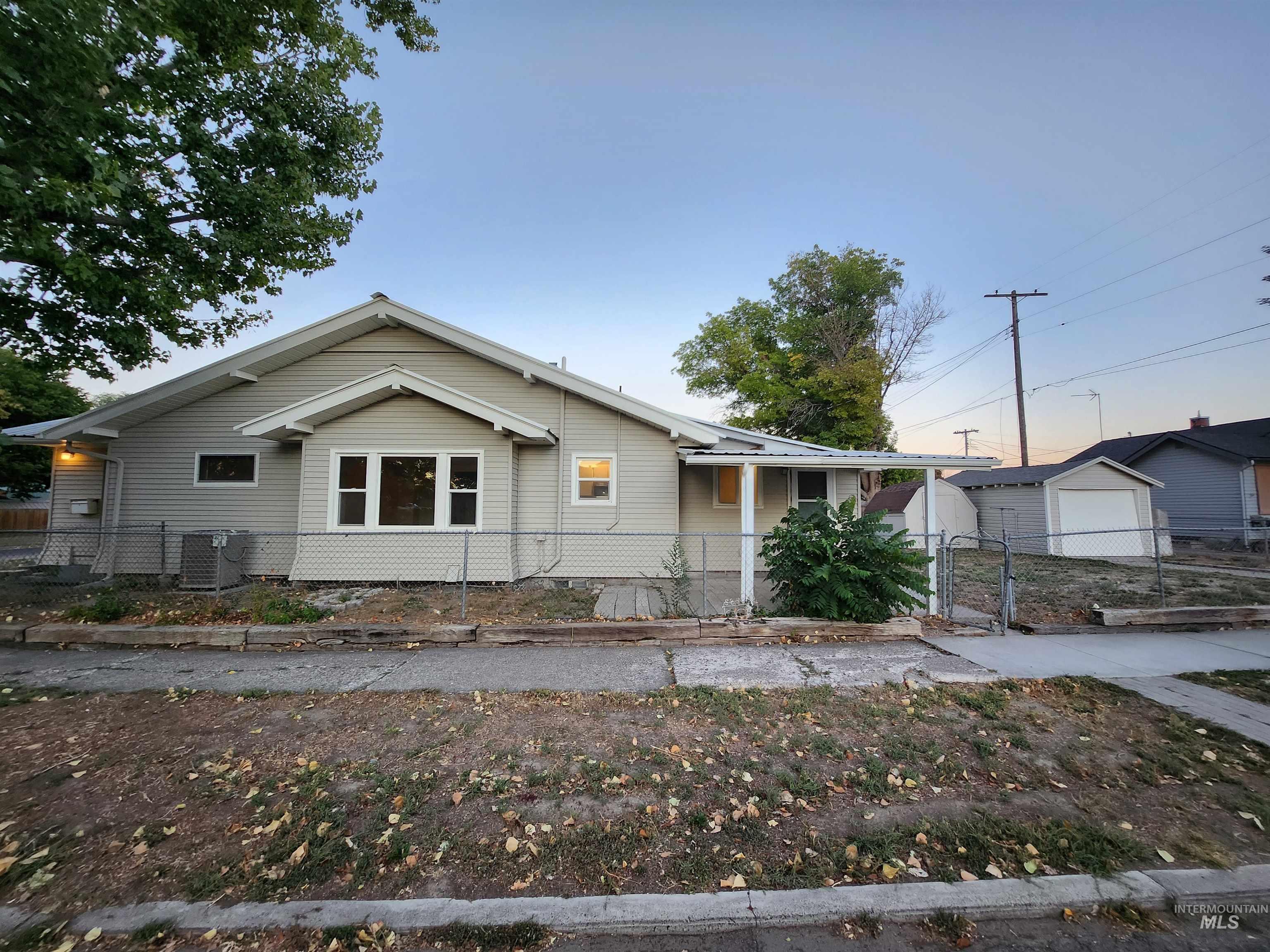 View of front of home with a fenced front yard and a garage