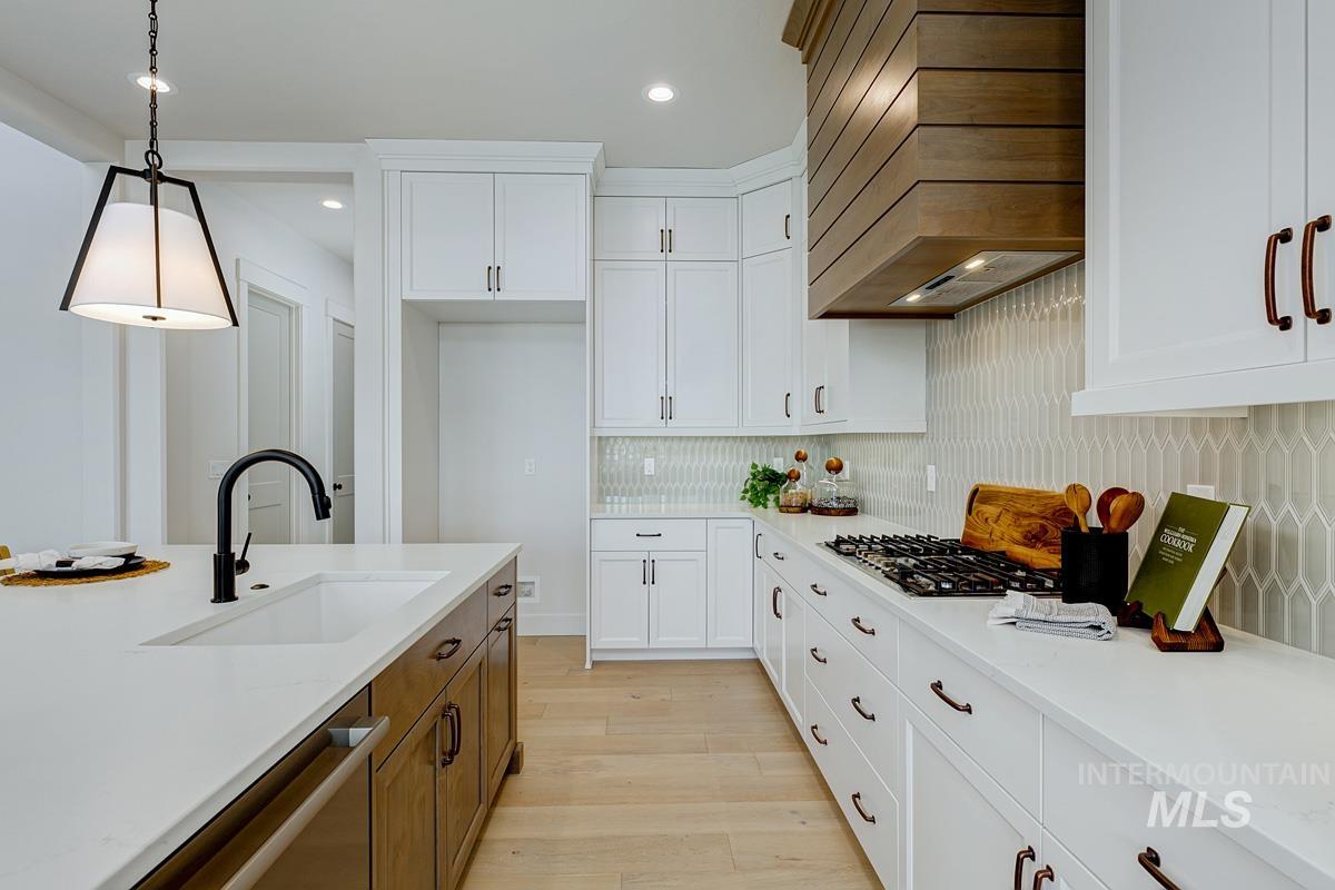 Kitchen featuring white cabinetry, light wood finished floors, pendant lighting, and recessed lighting