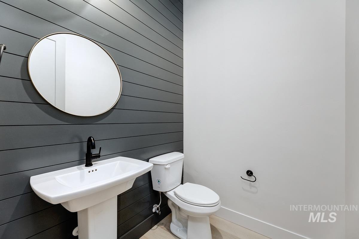 Bathroom featuring wood walls and toilet