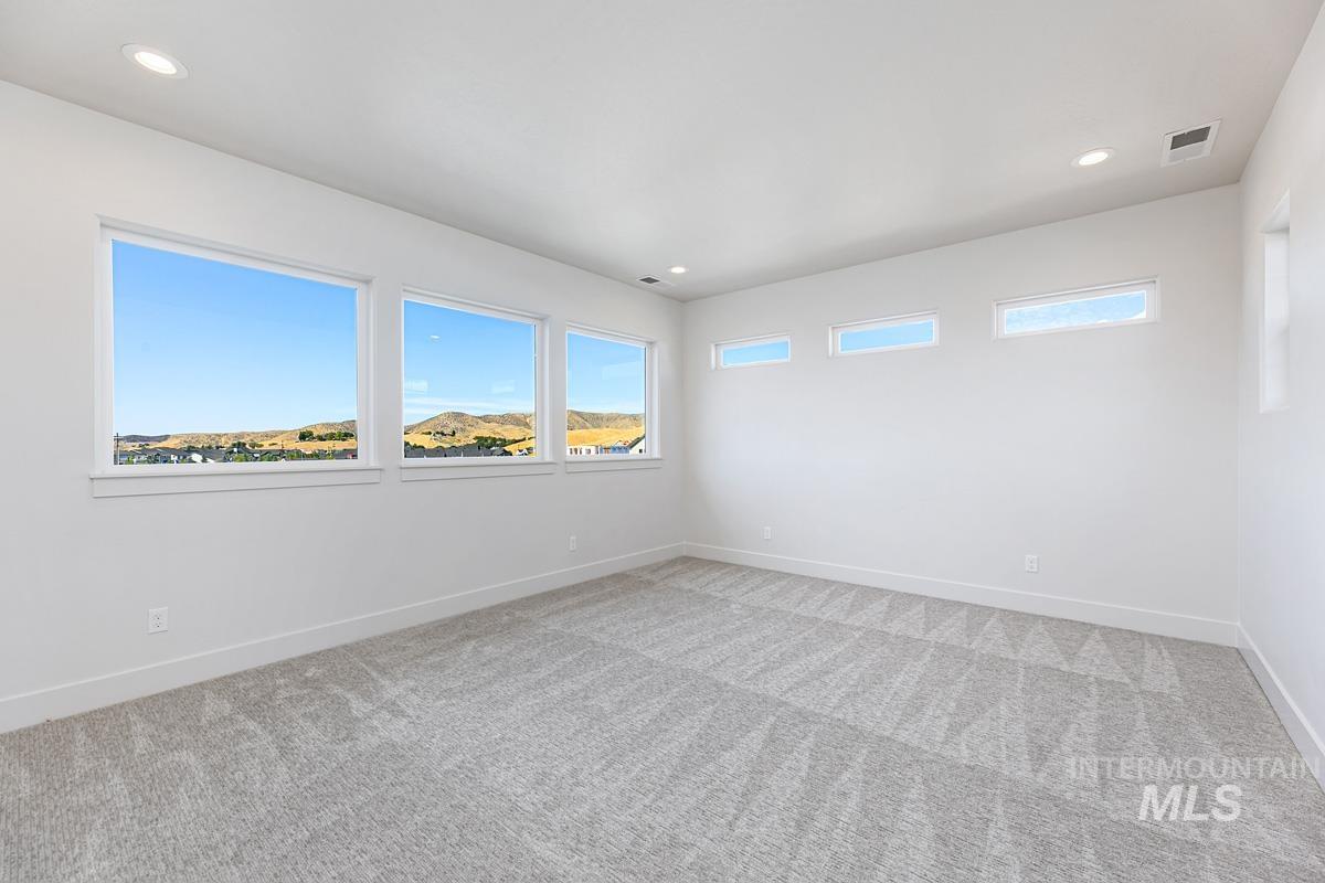 Empty room with recessed lighting and light carpet
