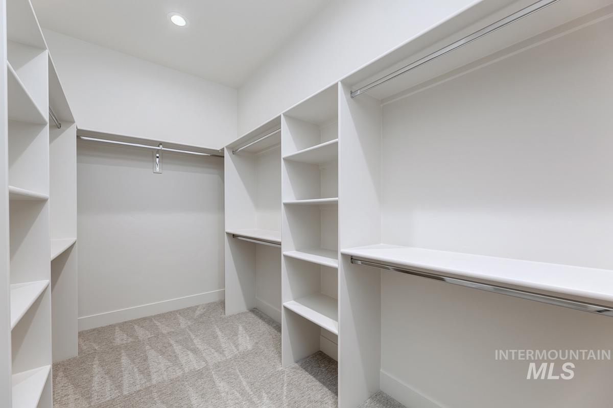 Spacious closet with light carpet