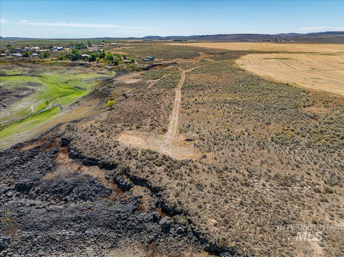 Aerial overview of property's location featuring rural landscape and a mountainous background