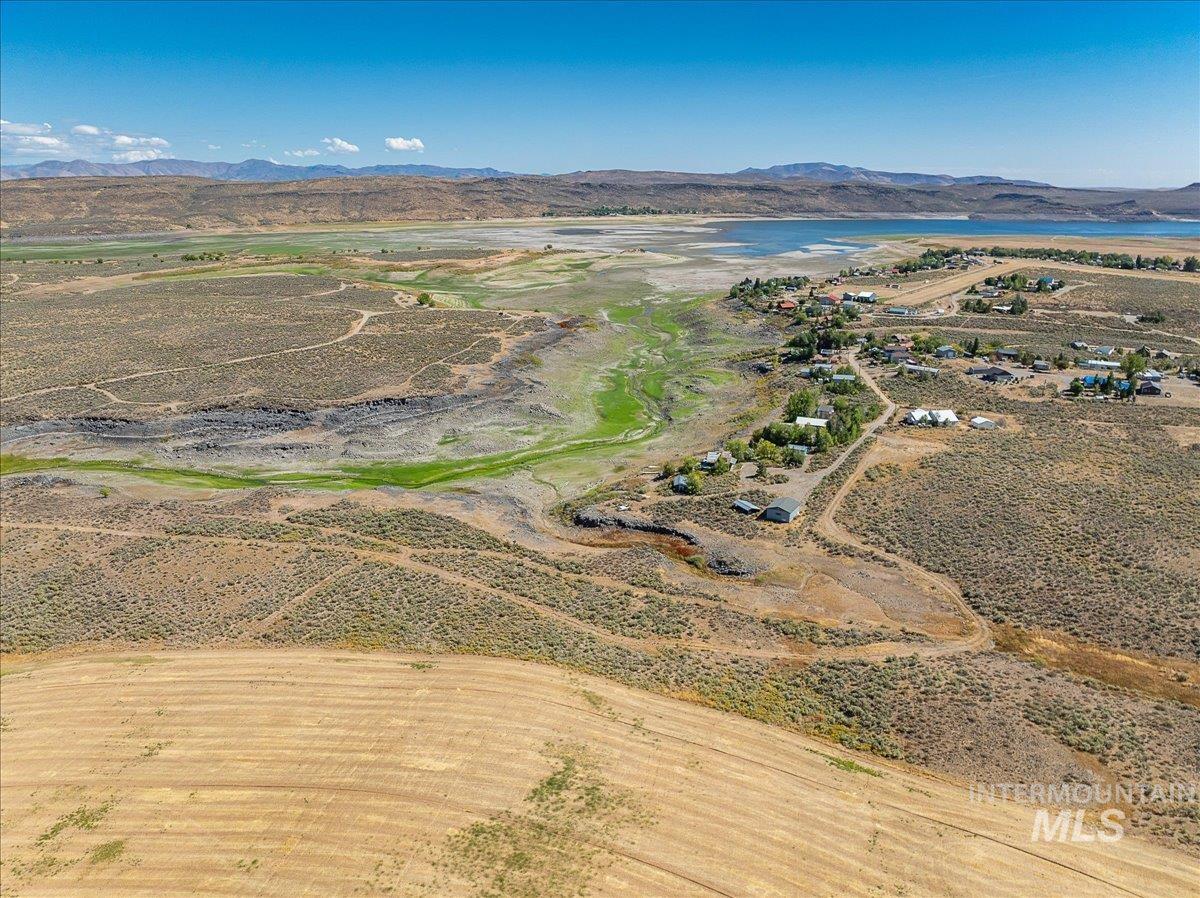 Aerial view of property and surrounding area with a water and mountain view