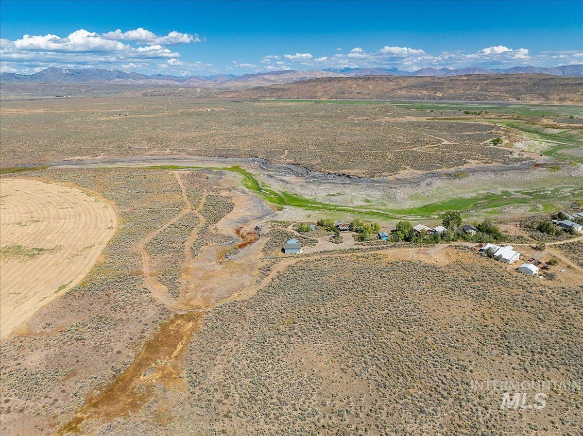 Aerial view of property and surrounding area with rural landscape and a mountain backdrop