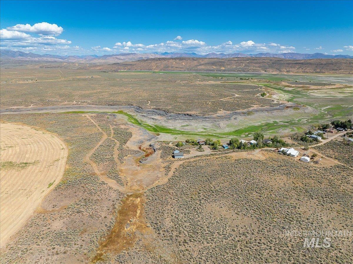 Aerial view of property and surrounding area with a mountain backdrop and rural landscape