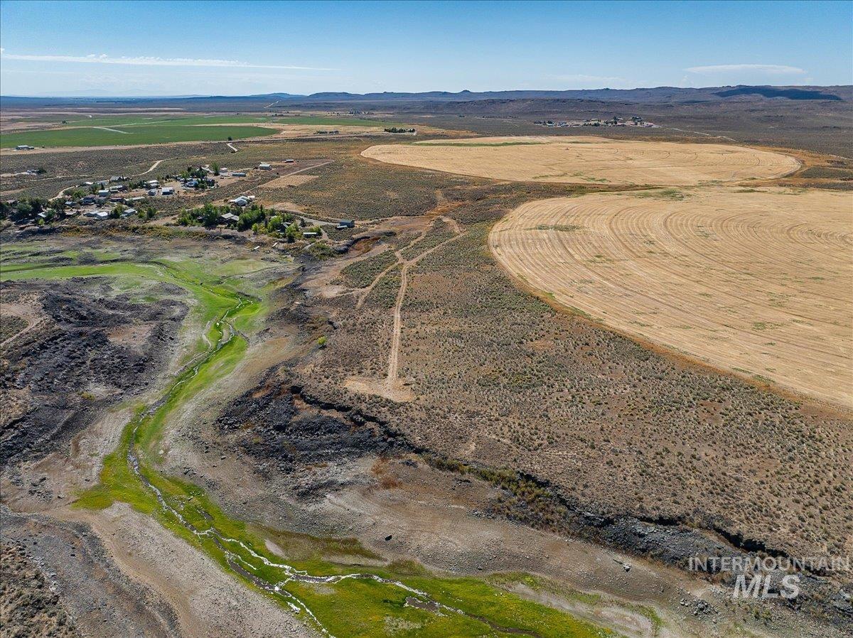 Aerial view of property's location featuring a mountain backdrop and rural landscape