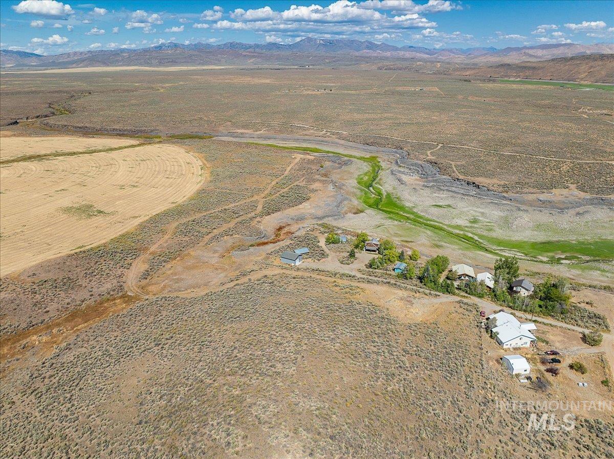 Aerial overview of property's location with rural landscape and a mountainous background