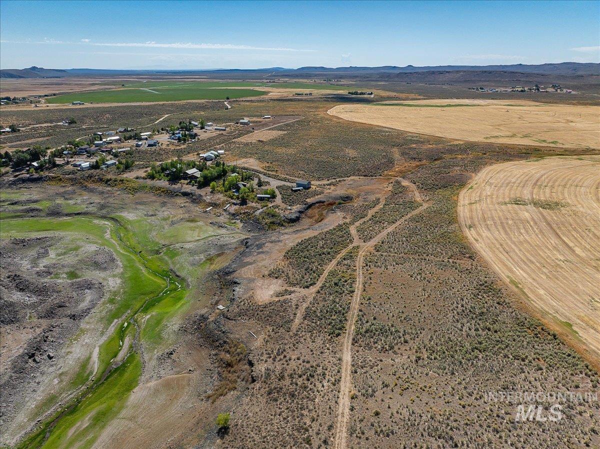 Aerial view of property and surrounding area with a mountainous background and rural landscape