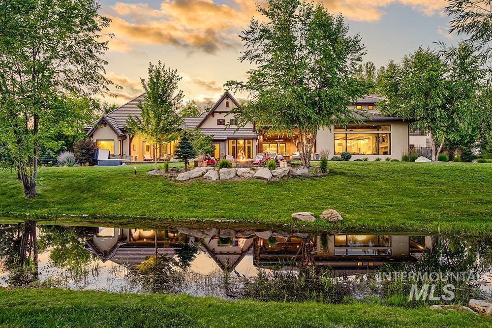 Back of property with a lawn and stucco siding