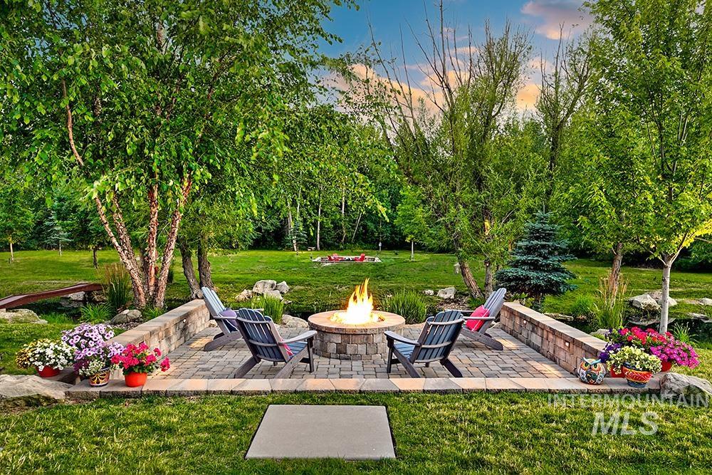 View of grassy yard with an outdoor fire pit and a patio