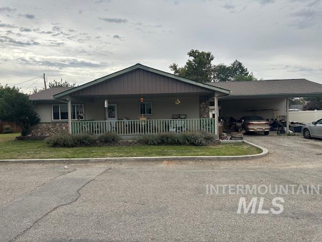 Single story home featuring covered porch, driveway, and an attached carport