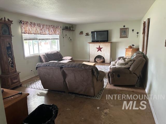 Living area with baseboards and a textured ceiling