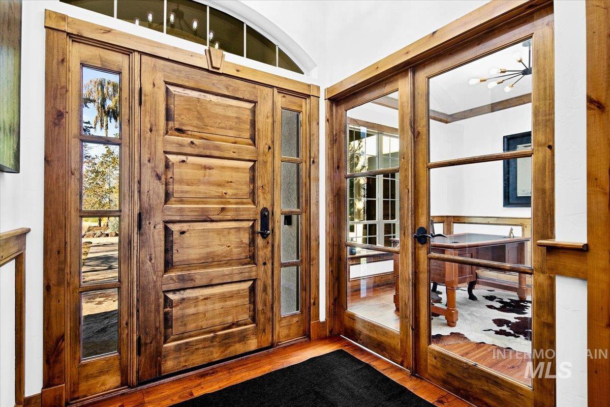 Double wood-panel entry doors with sidelights, complemented by an arched transom window