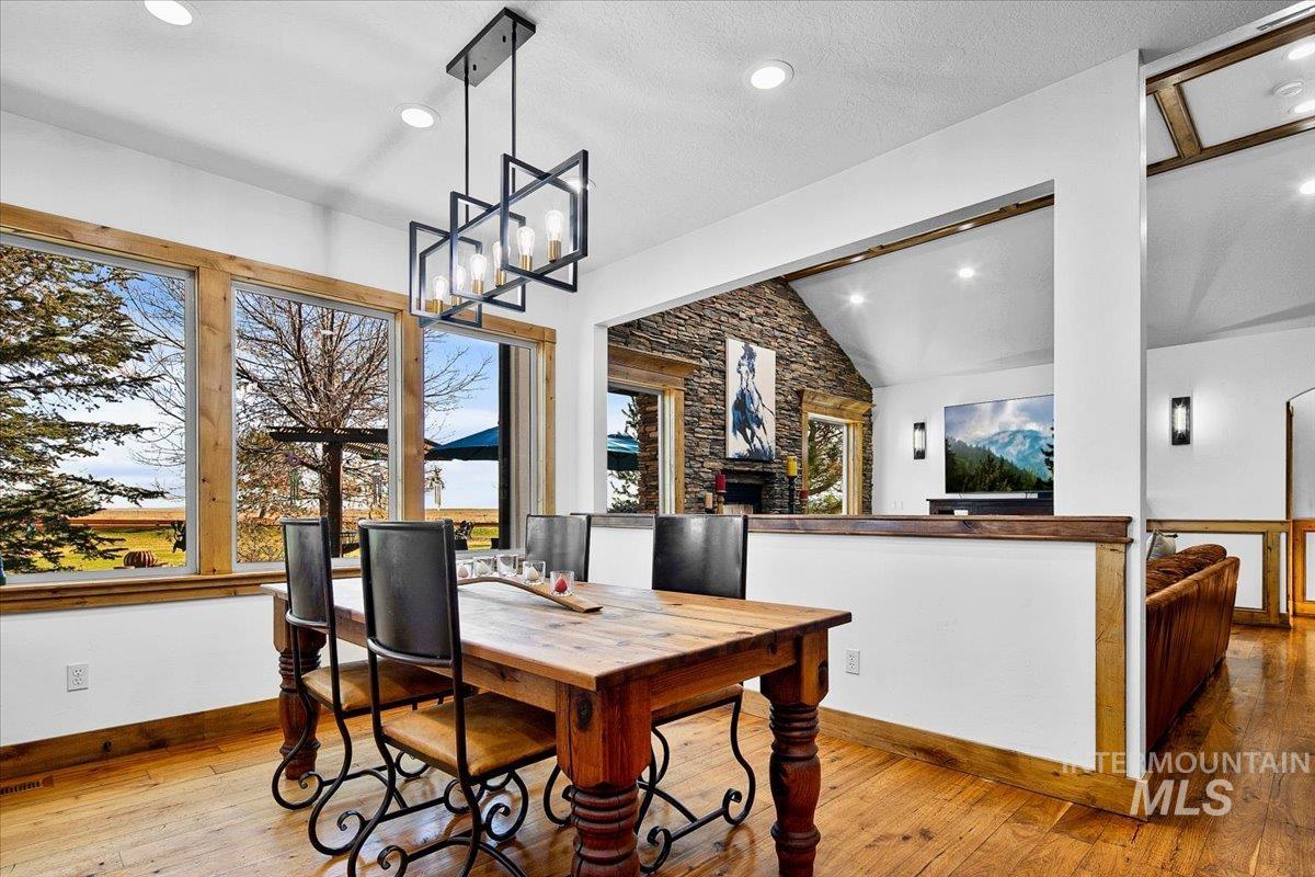 Dining area featuring a rectangular wood dining table, a linear chandelier with geometric black frames, and wood-finish flooring