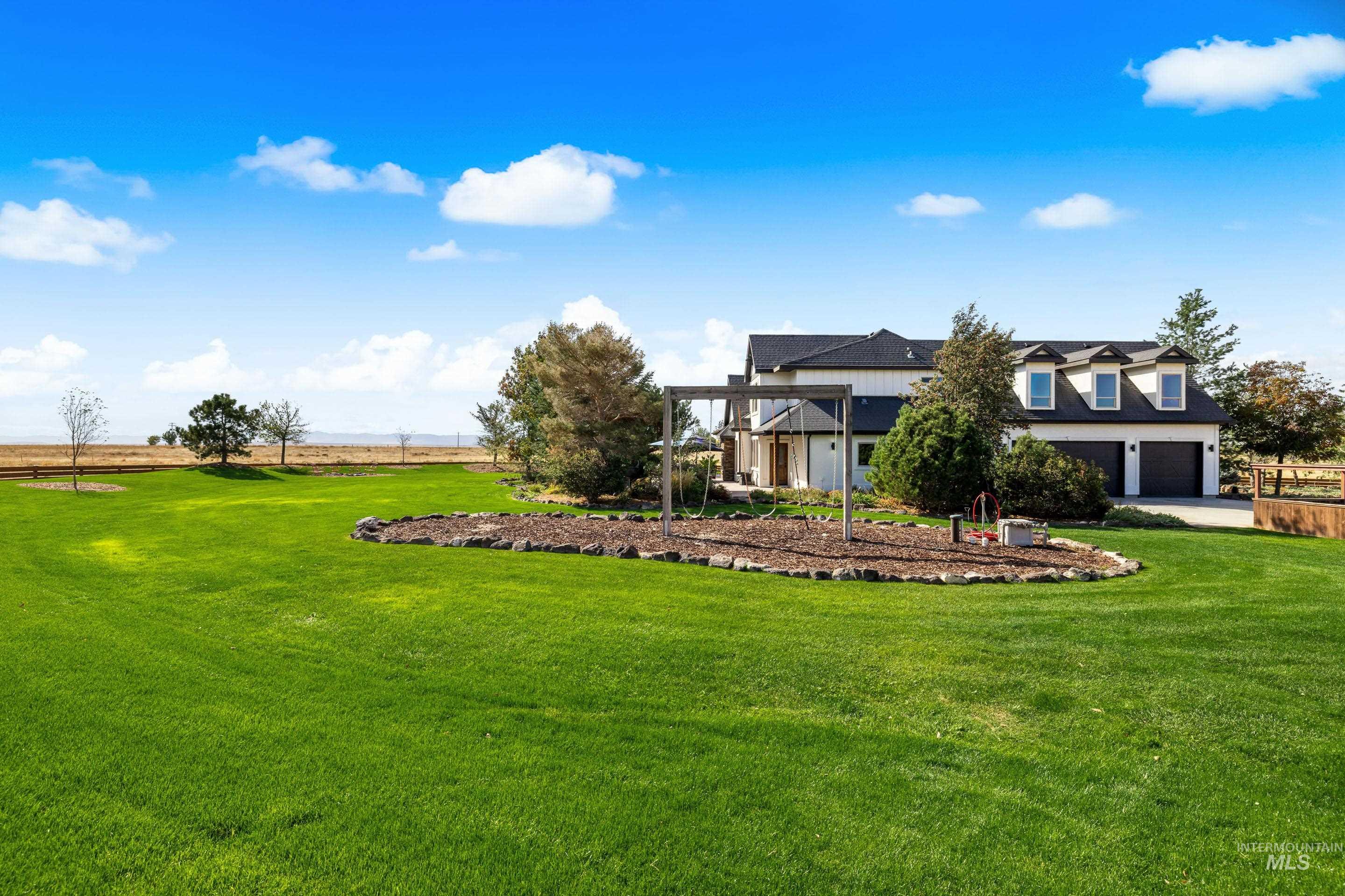 Expansive green lawn bordering a stone-edged garden bed