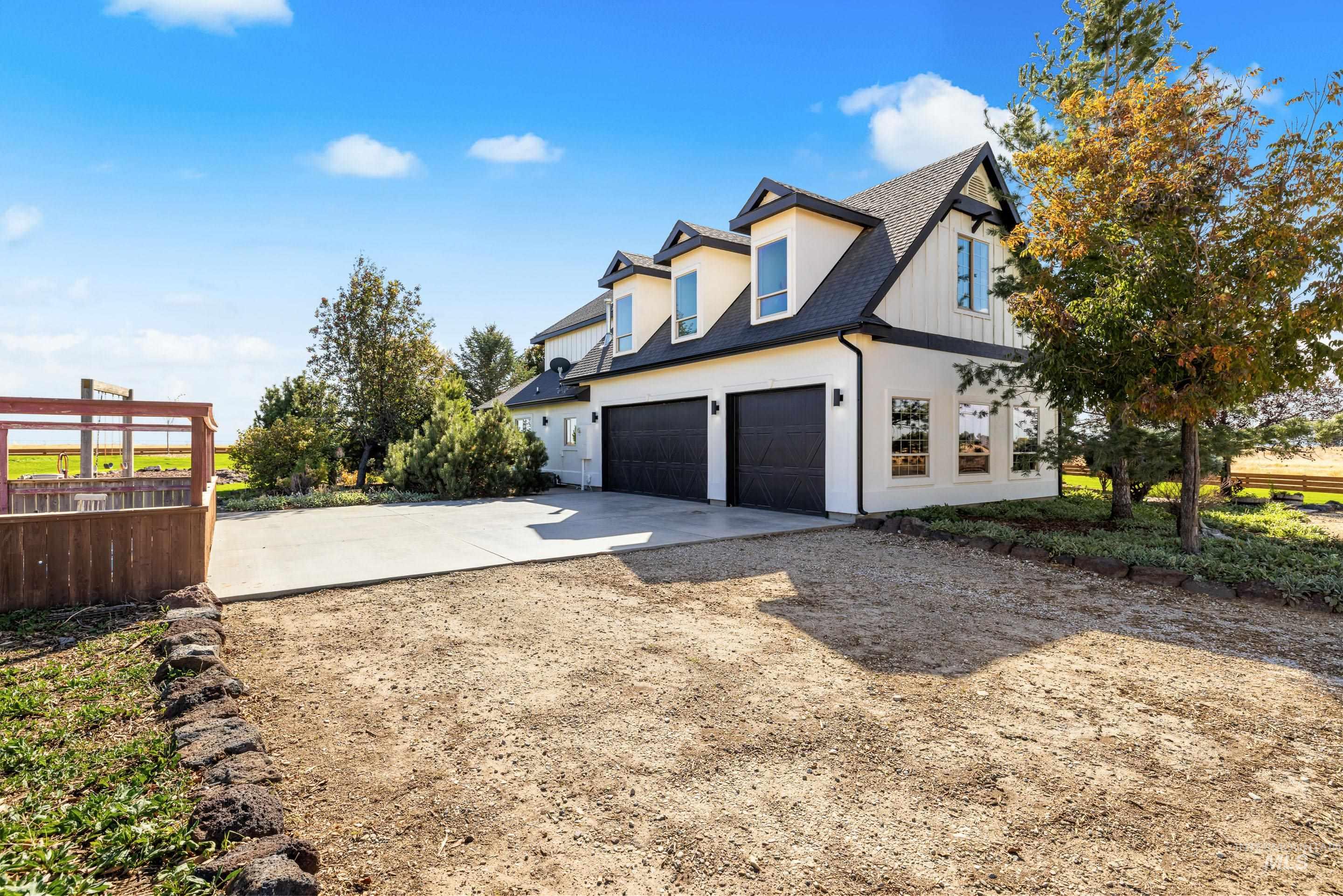 Modern farmhouse exterior with white vertical siding and black trim accents
