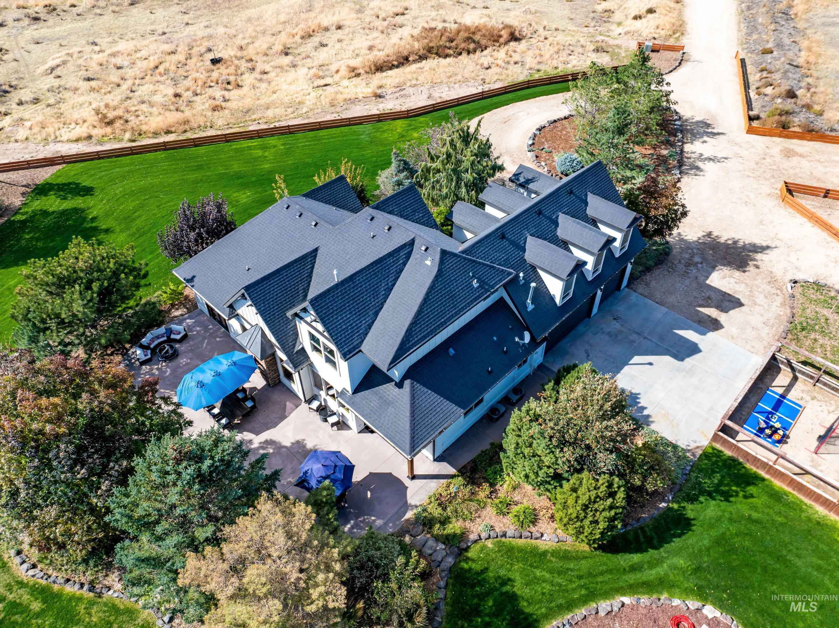 White exterior residence featuring a dark-toned roofline, dormer windows, and a concrete driveway