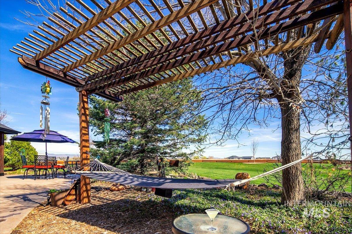 Expansive outdoor area featuring a louvered pergola over a patio